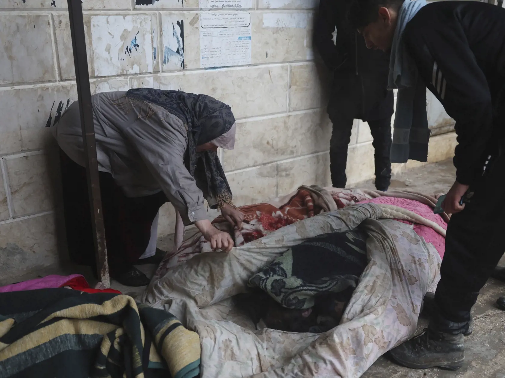 WA 37 Azmarin - Žena identifikuje telá obetí zemetrasenia v meste Azmarin v provincii Idlib na severe Sýrie v pondelok 6. februára 2023.