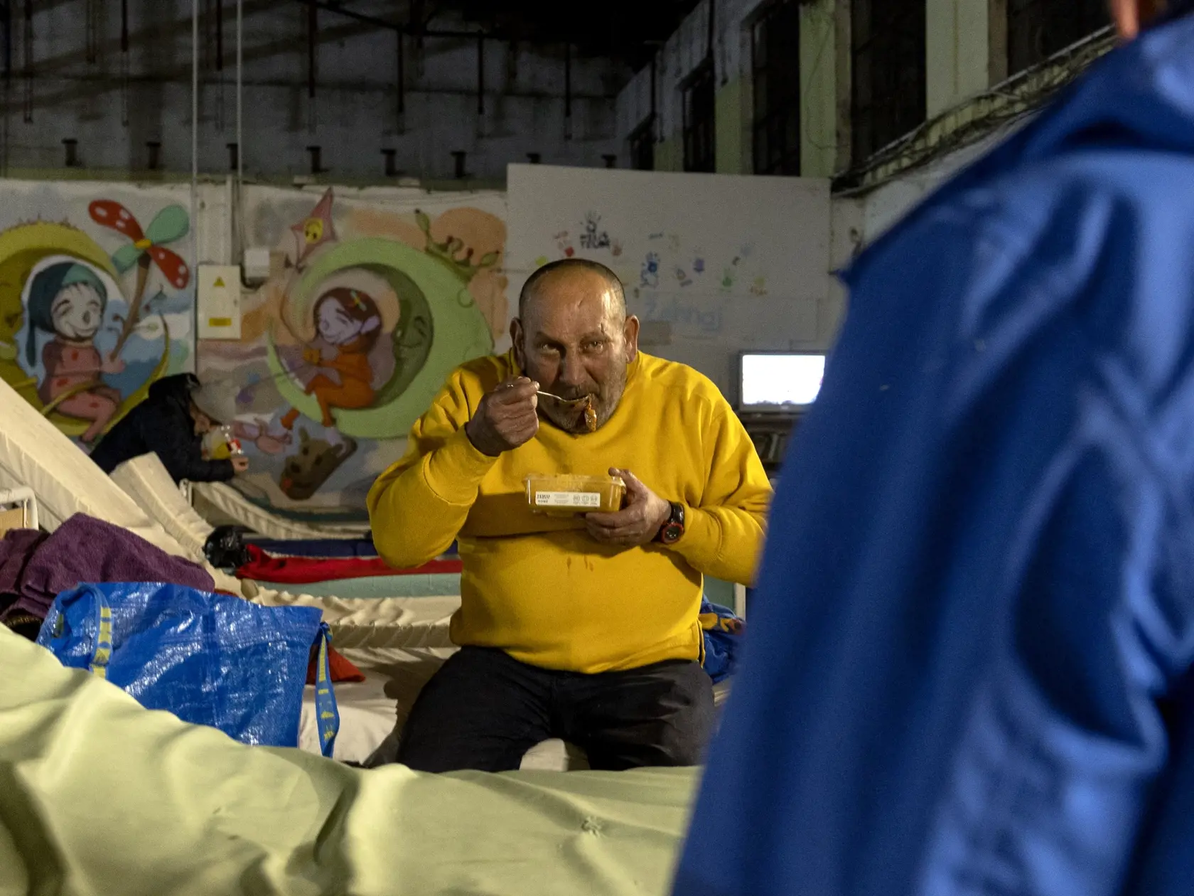 Klienti nocľahárne si po dlhom a mrazivom dni vychutnávajú teplú večeru.