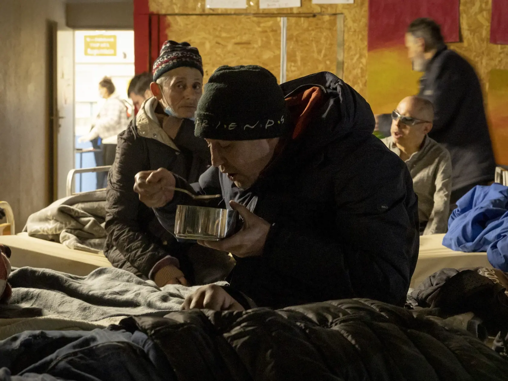 Klienti nocľahárne si po dlhom a mrazivom dni vychutnávajú teplú večeru.