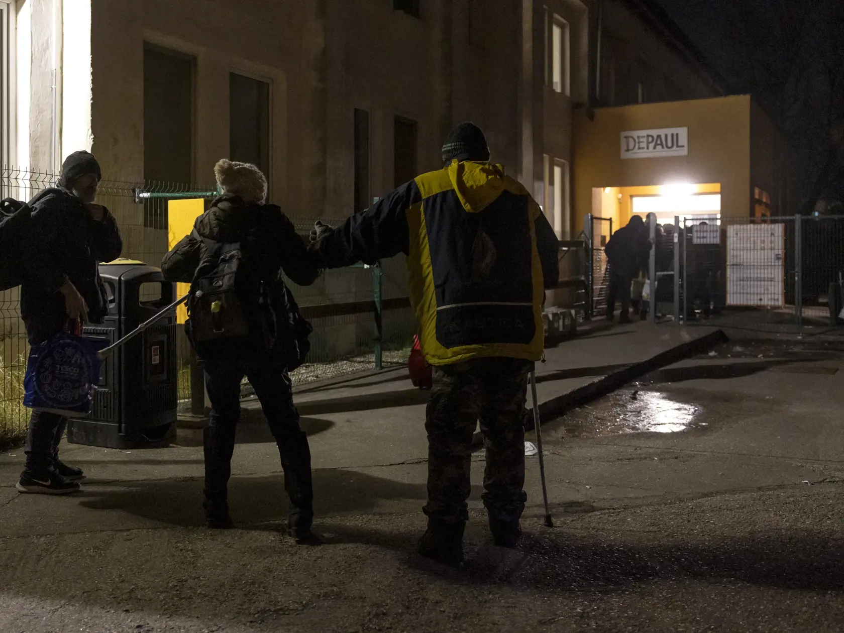 Klienti čakajú, kým sa dvere nocľahárne konečne otvoria.