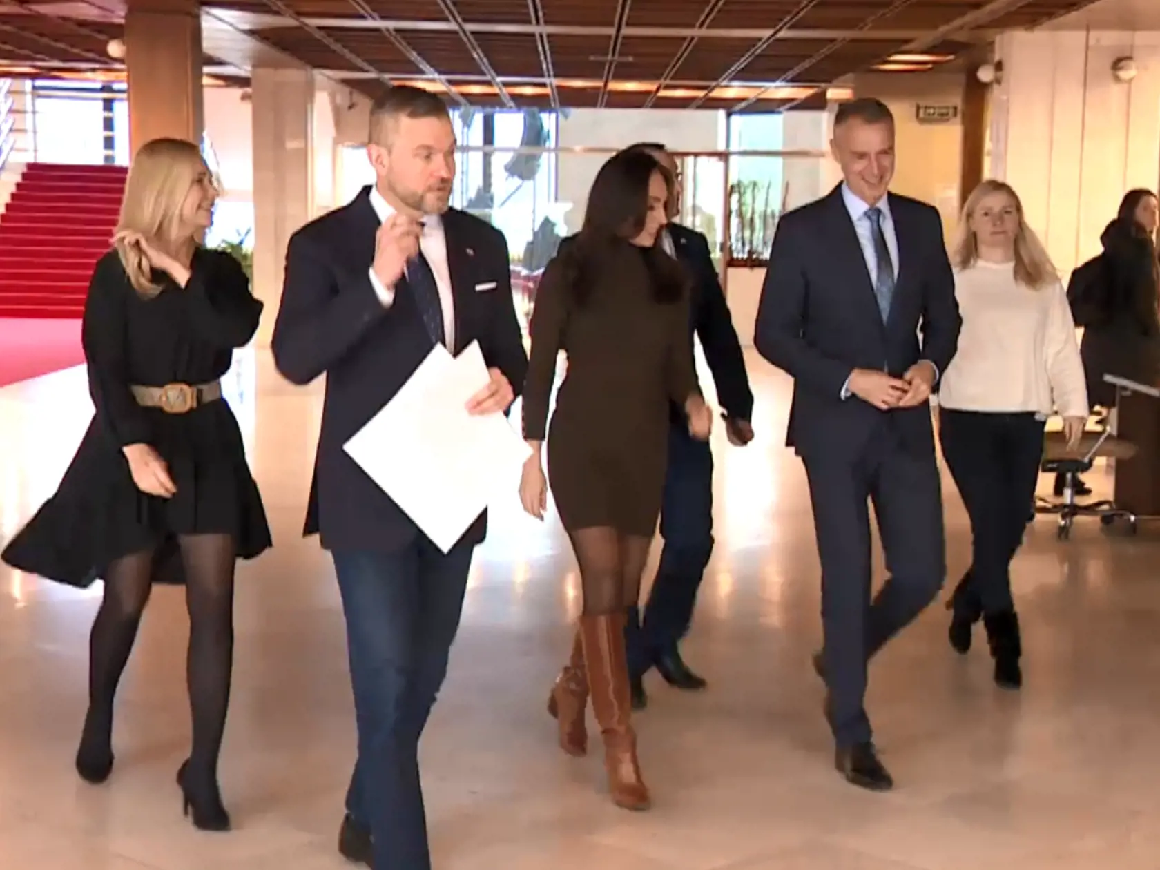 Saková si uvedomovala, že vyzerá dobre, čo dávala najavo úsmevom a tým, že si pomerne neobvyklým spôsobom pridržiavala vlasy, resp. sa s nimi pohrávala.