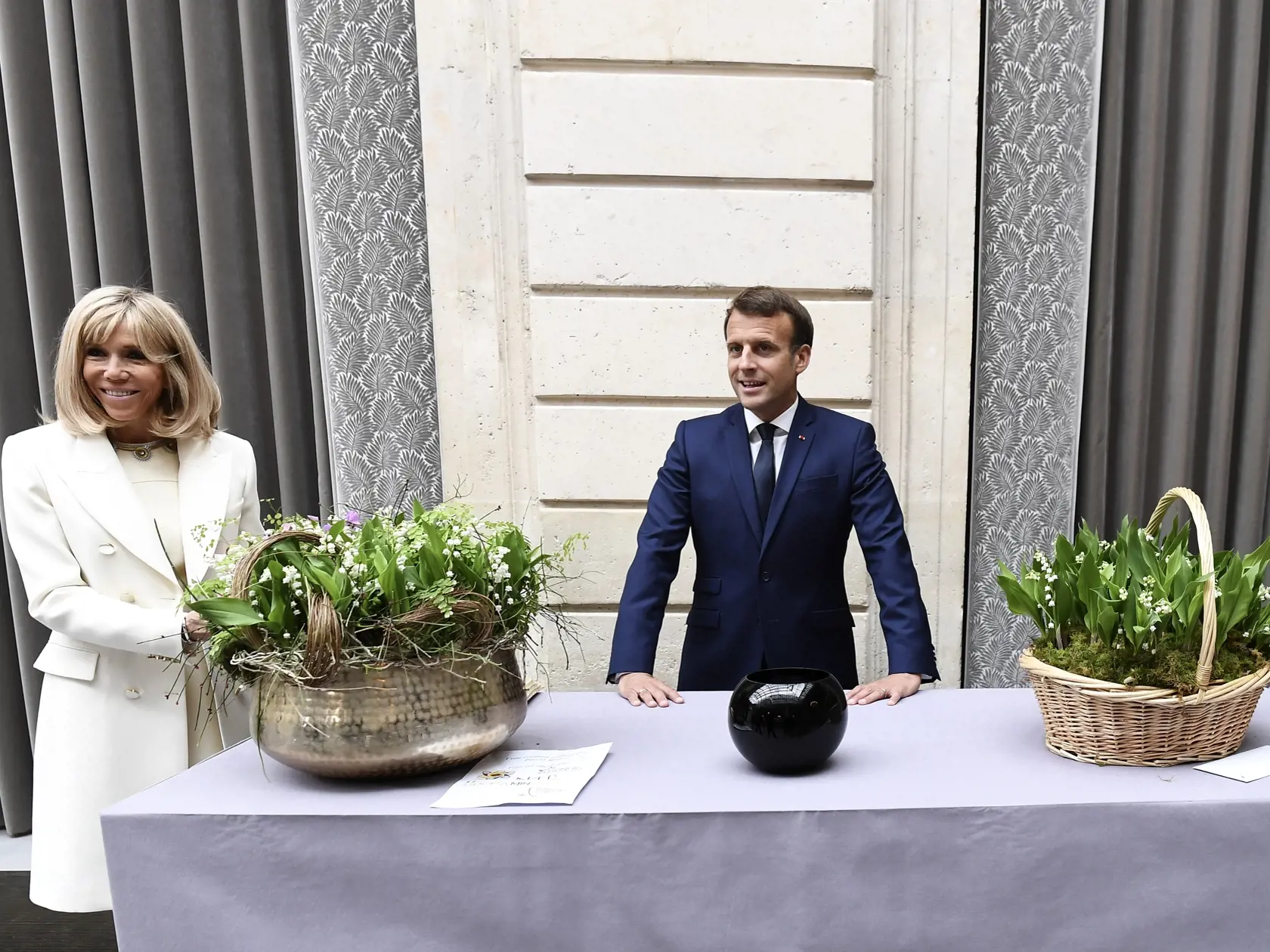 KK44 Paríž - Francúzsky prezident Emmanuel Macron a jeho manželka Brigitte Macronová počas ceremoniálu 1. mája 2020 v Paríži. Francúzsky prezident Emmanuel Macron v piatok občanov upozornil, že uvoľnenie celoštátnych obmedzení pohybu 11. mája bude len prvým krokom na ceste z krízy spôsobenej epidémiou nového koronavírusu.  FOTO TASR/AP
French President Emmanuel Macron and his wife Brigitte Macron attend the traditional Lily of the Valley ceremony at the Elysee palace, Friday, May 1, 2020 in Pari