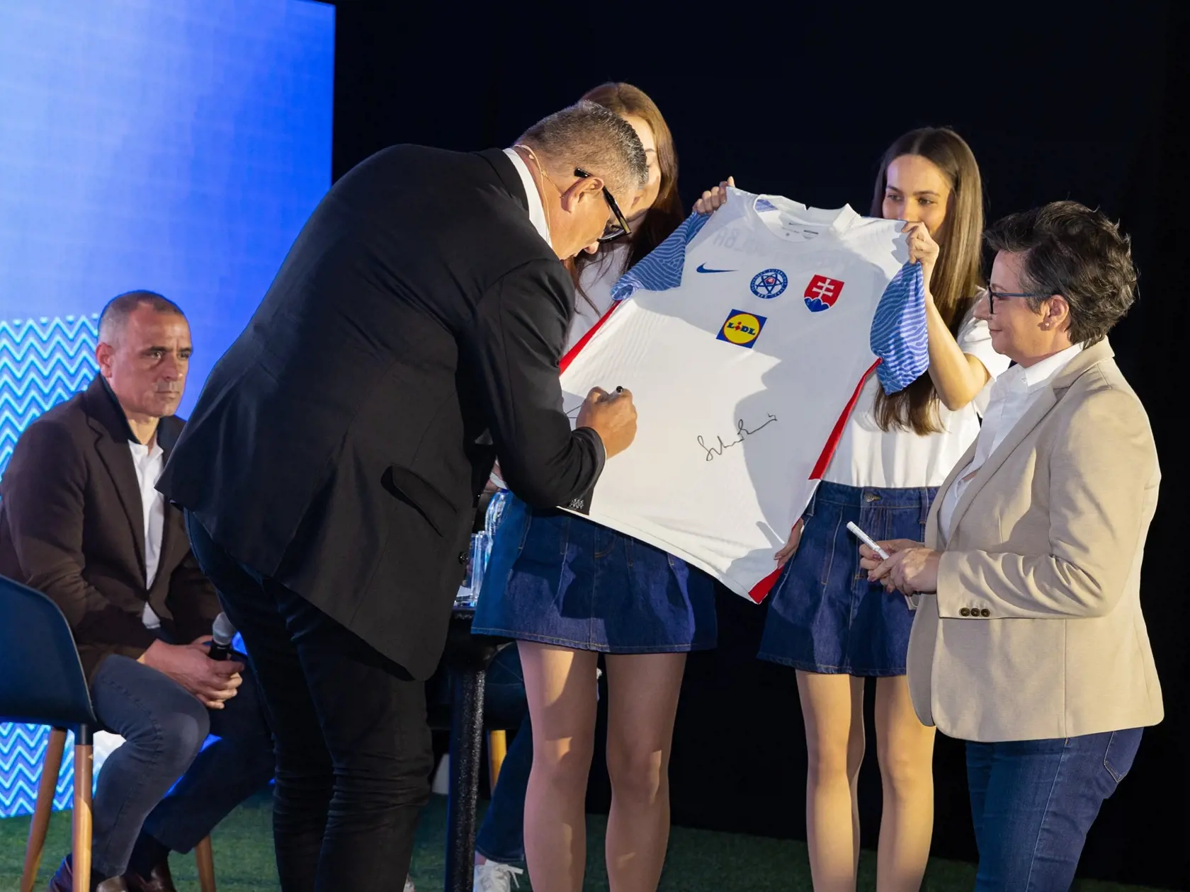 Prezident SFZ Ján Kováčik podpisuje dres Zite Szlavikovics, generálnej riaditeľke Lidl Slovenská republika.