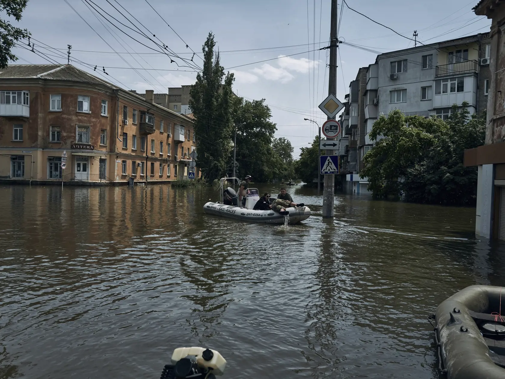 Dobrovoľníci evakuujú na člne miestneho obyvateľa zo zaplavených oblastí v ukrajinskom meste Cherson 8. júna 2023.
