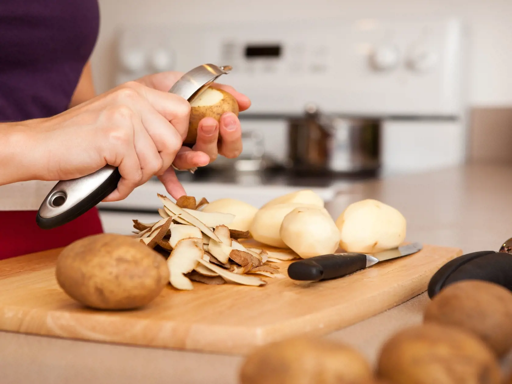 Color Image of Woman Peeling Potatoes in Her Kitchen