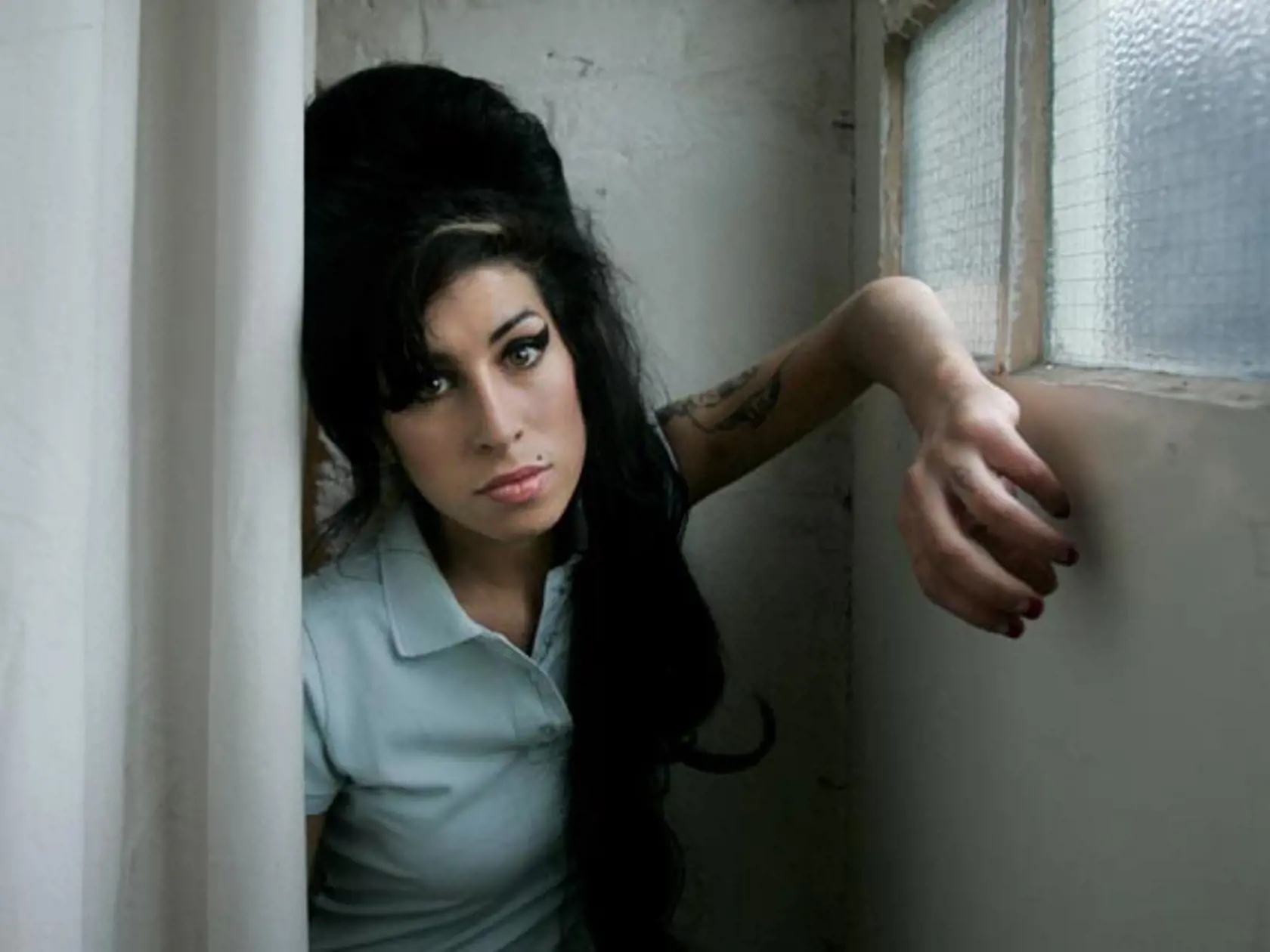 FILE - In this Feb. 16, 2007 file photo, British singer Amy Winehouse poses for photographs after being interviewed by The Associated Press at a studio in north London, Friday, Feb. 16, 2007. British police say singer Amy Winehouse has been found dead at her home in London on Saturday, July 23, 2011. The singer was 27 years old. (AP Photo/Matt Dunham, File)