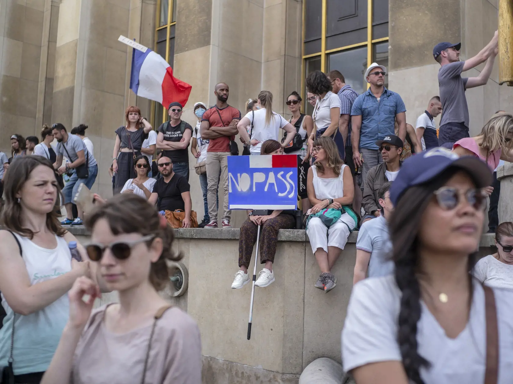 Na snímke ľudia počas protestu proti návrhu zákona, ktorý vstup do reštaurácií a na iné miesta podmieňuje predložením dokladu o očkovaní proti ochoreniu COVID-19 alebo negatívnym výsledkom testu na covid, 24. júla 2021 v Paríži.