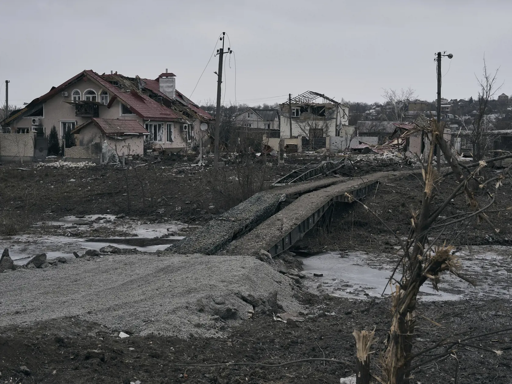 Na snímke sú zničené rodinné domy a cesta v meste Bachmut na východe Ukrajiny vo štvrtok 12. januára 2023.