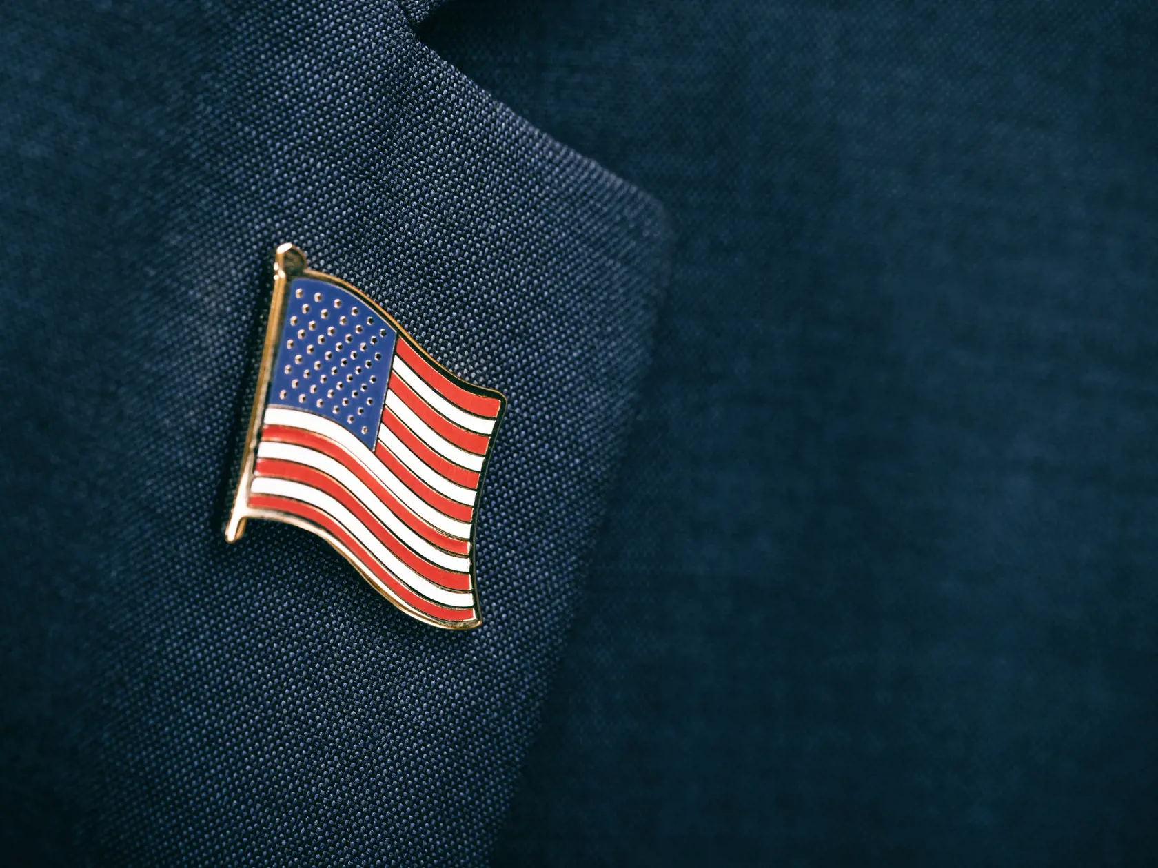Element of male suit with USA flag pinned at chest area