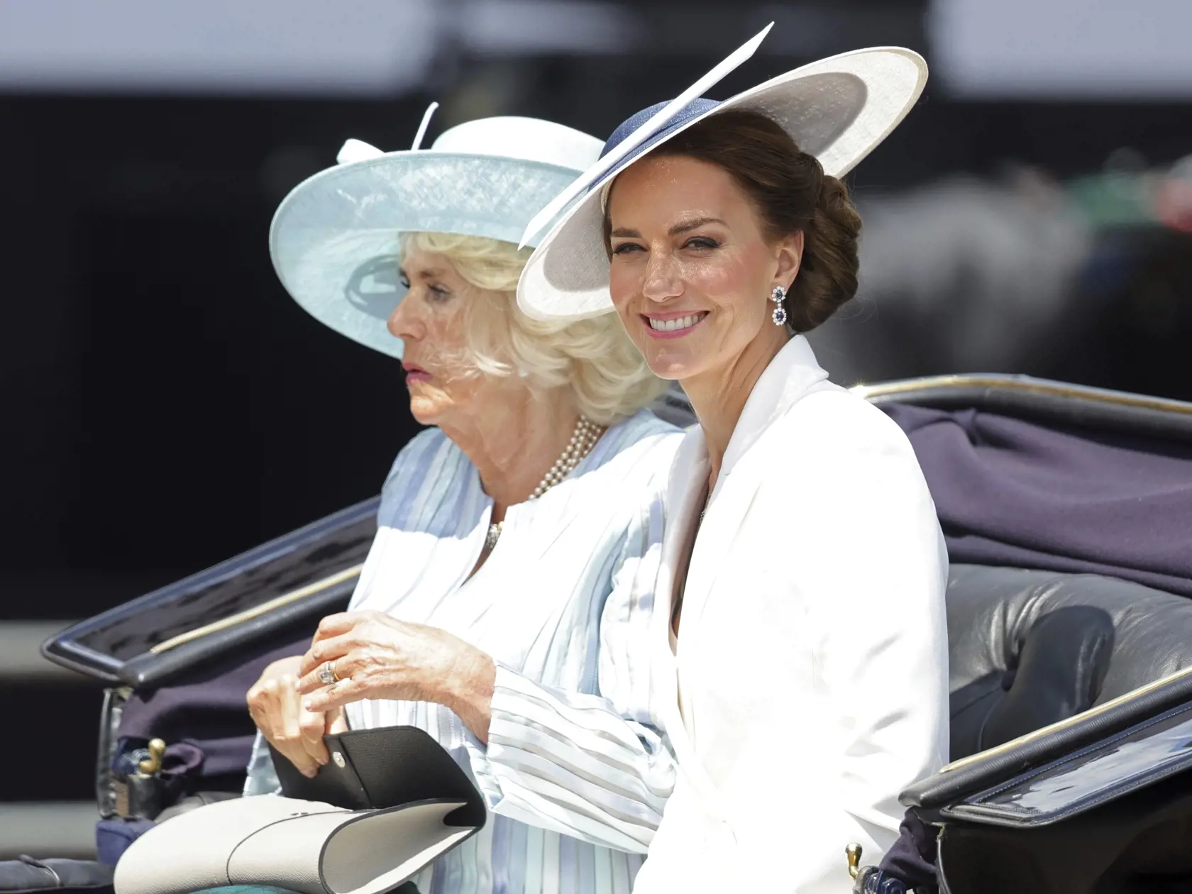 Na snímke zľava Camila, vojvodkyňa z Cornwallu a Kate, vojvodkyňa z Cambridgeu sedia v koči počas slávnostného vojenského sprievodu (Trooping the Color), ktorým sa začali štvordňové oslavy 70. výročia nástupu britskej kráľovnej Alžbety II. na trón v Londýne vo štvrtok 2. júna 2022.