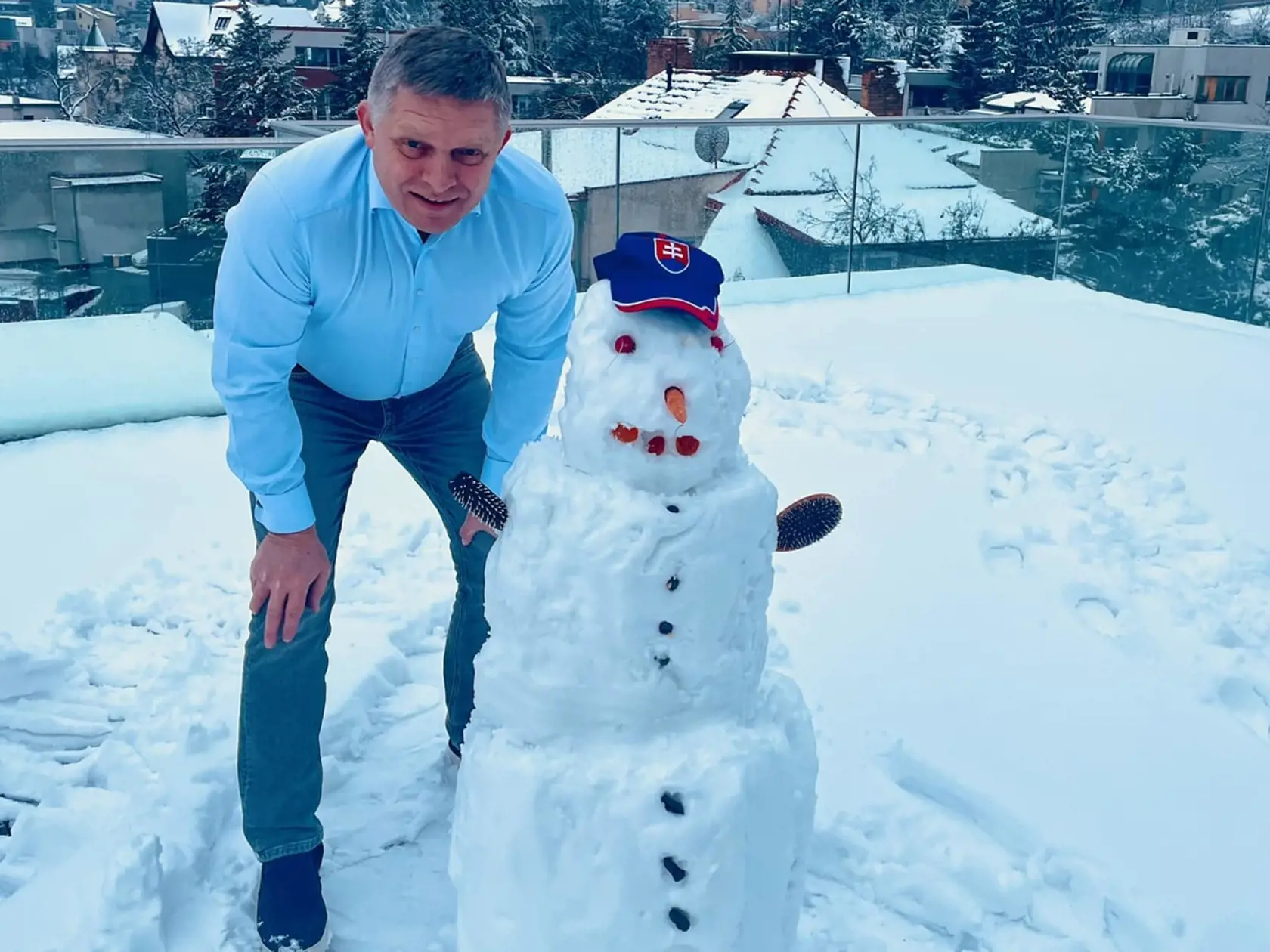 Robert Fico pri stavaní snehuliaka.