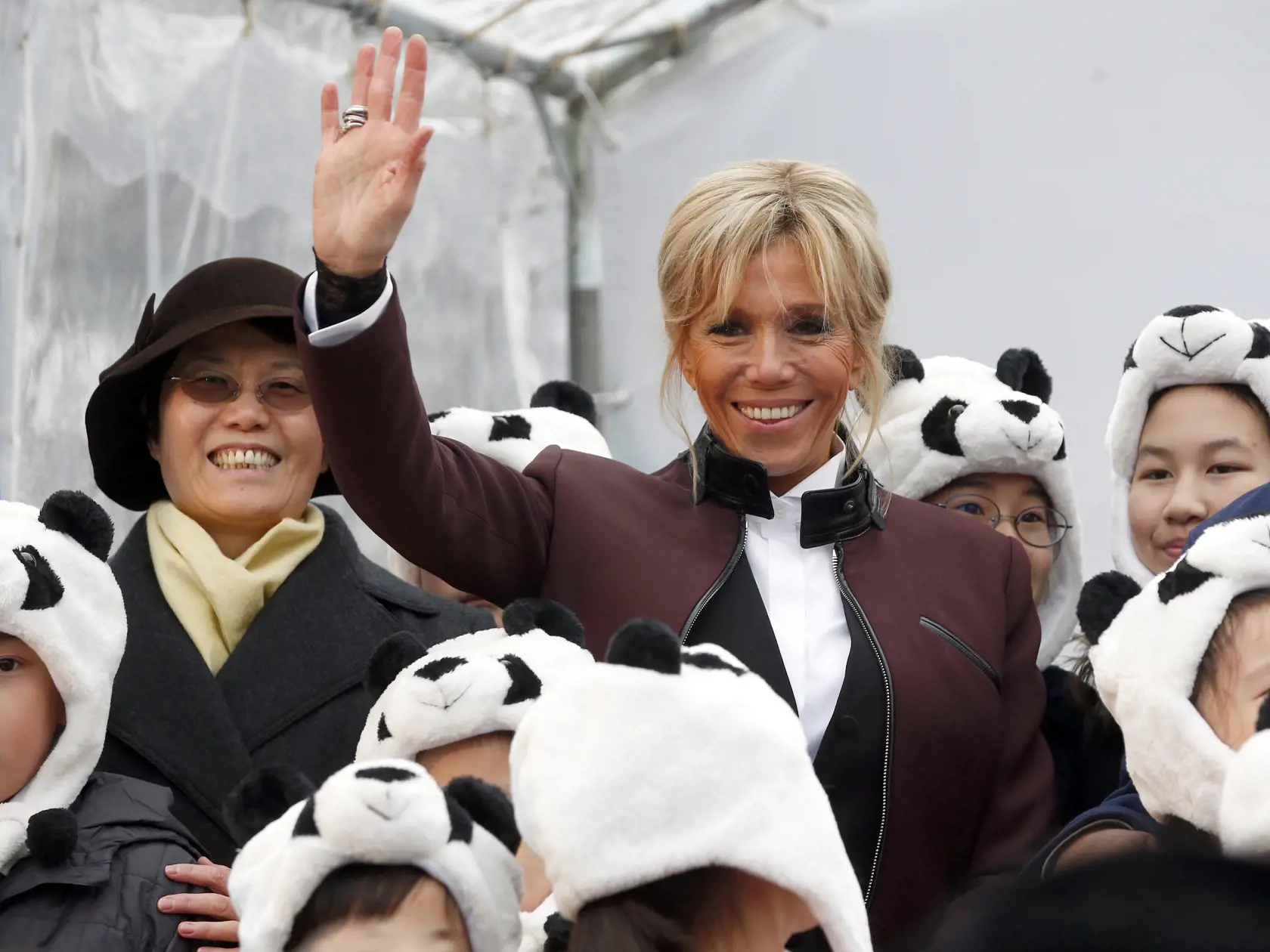French First lady Brigitte Macron waves as she poses with children dressed in panda outfits during a naming ceremony of the panda born at the Beauval Zoo in Saint-Aignan-sur-Cher, France, Monday, Dec. 4, 2017. The 4-month-old cub is called Yuan Meng, which means "the realization of a wish" or "accomplishment of a dream." (AP Photo/Thibault Camus, Pool)