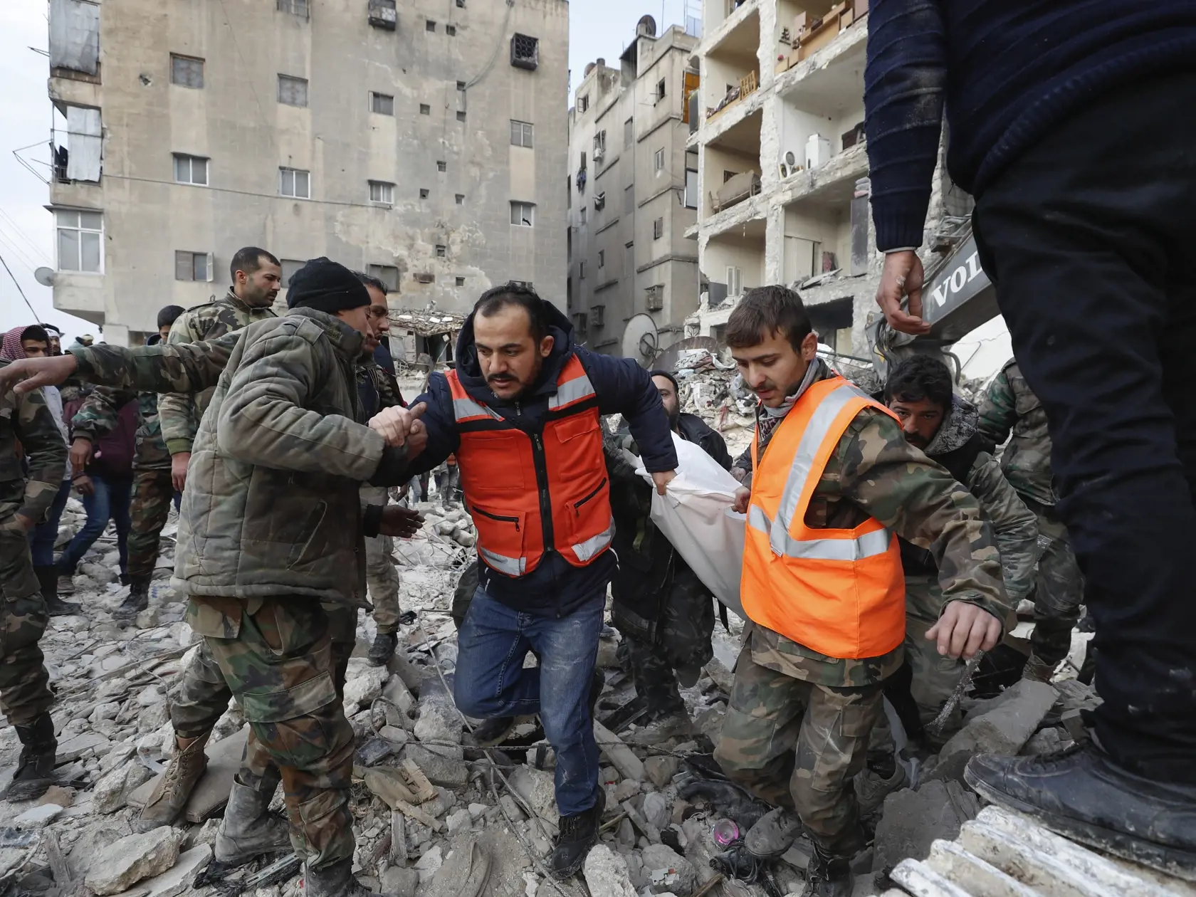 WA 47 Aleppo - Záchranné tímy nesú telo obete zemetrasenia v sýrskom meste Aleppo v utorok 7. februára 2023.  Turecko a jeho pohraničie so Sýriou zasiahlo v noci na pondelok silné zemetrasenie s magnitúdou 7,8, ktoré si spolu s dotrasmi vyžiadalo viac ako 4300 obetí na životoch.