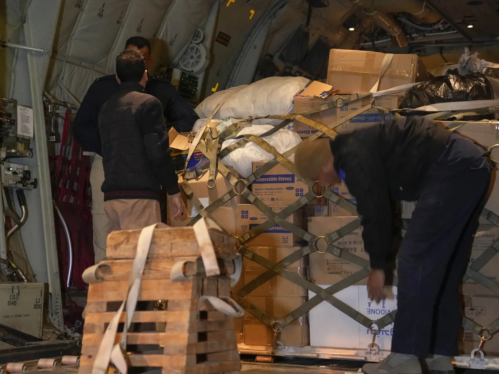 JB 58 Bagdad - Príslušníci irackých bezpečnostných síl nakladajú potravinovú pomoc Červeného polmesiaca do lietadla pred odletom do Turecka, ktoré postihlo silné zemetrasenie na medzinárodnom letisku v Bagdade 8. februára 2023.
