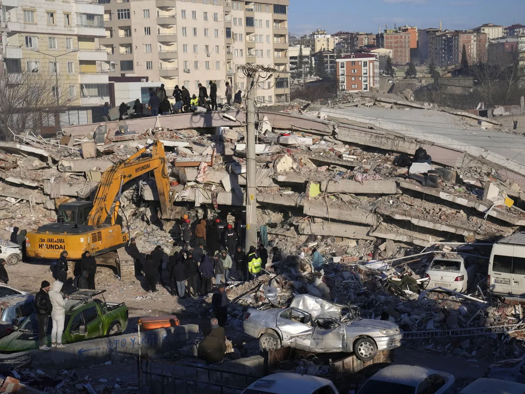 JB 60 Kahramanmaras - Ľudia a záchranári prehľadávajú trosky zrútenej budovy v meste Kahramanmaras na juhu Turecka 8. februára 2023.