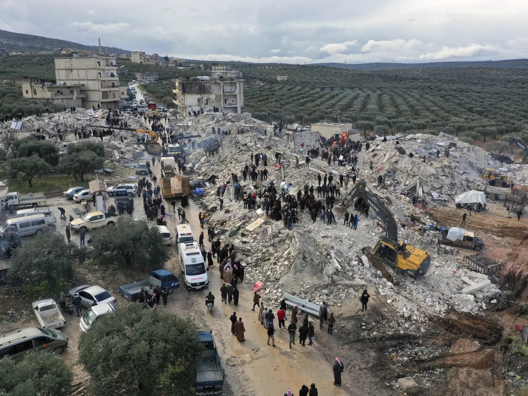KK2 Harem - Pracovníci civilnej obrany a obyvatelia prehľadávajú ruiny zrútených budov v meste Harem pri tureckých hraniciach v sýrskej provincii Idlib 6. februára 2023.