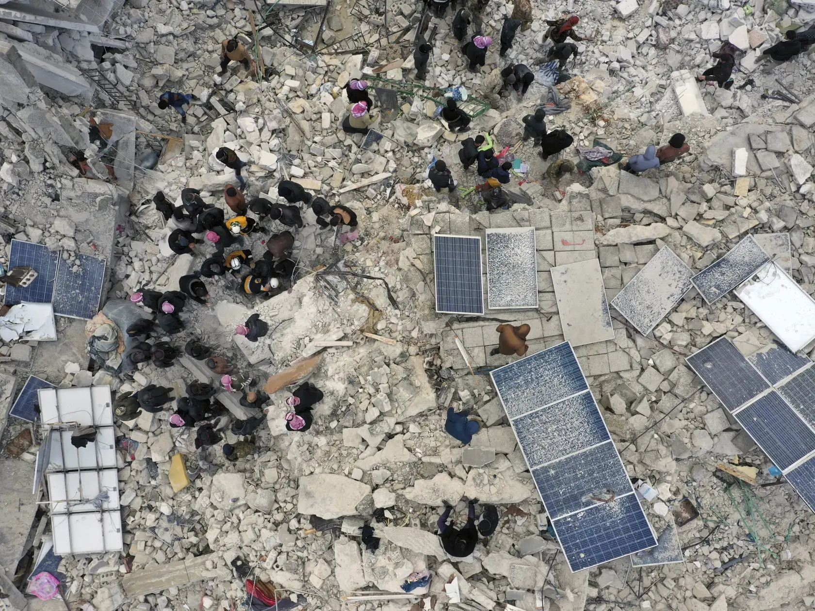 KK4 Harem - Pracovníci civilnej obrany a obyvatelia prehľadávajú ruiny zrútených budov v meste Harem pri tureckých hraniciach v sýrskej provincii Idlib 6. februára 2023.
