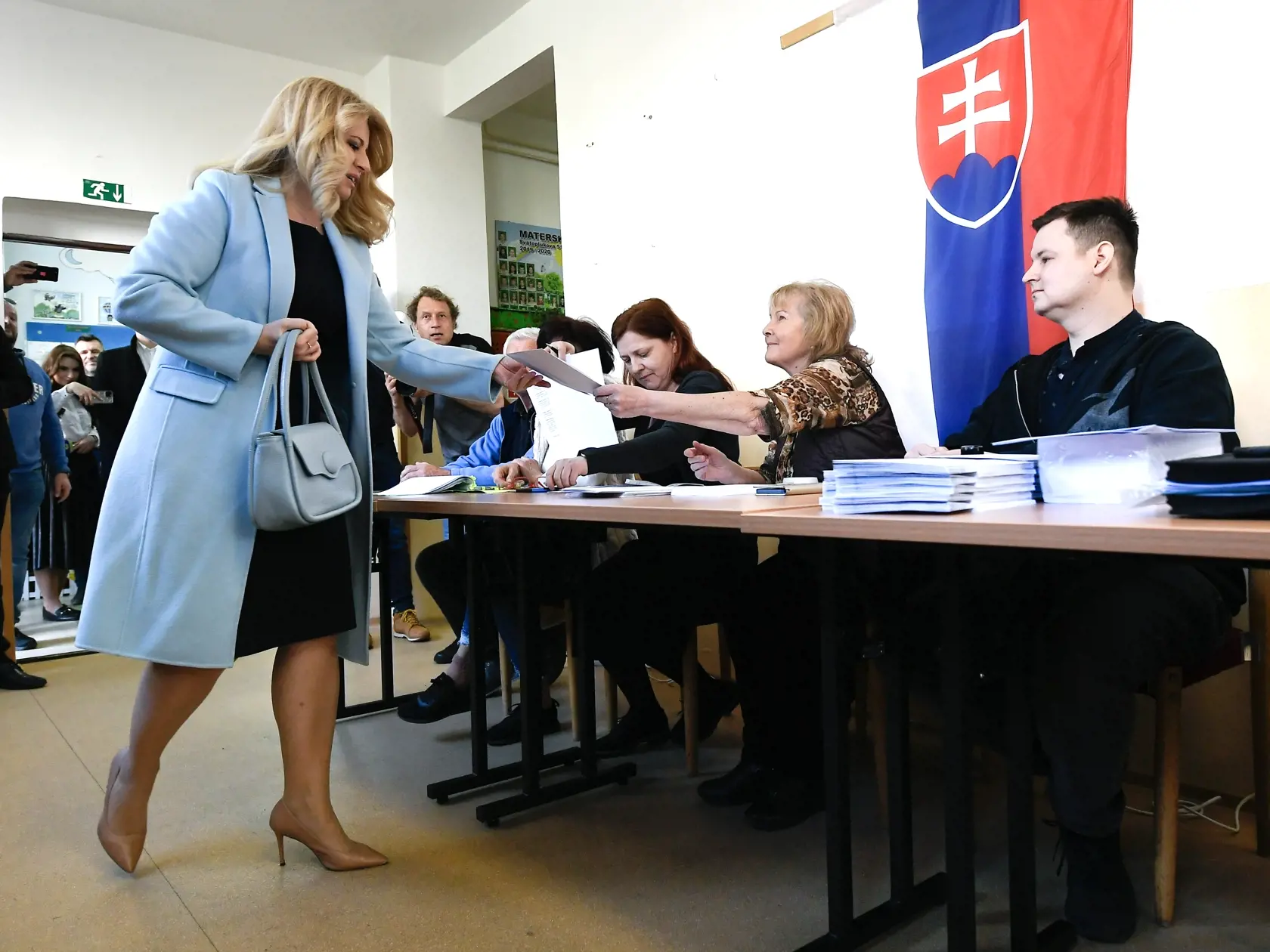 Na Slovensku sa v sobotu začali voľby prezidenta Slovenskej republiky. Voľby prezidenta sú dvojkolové a občania si v prvom kole môžu vybrať z deviatich kandidátov. V prípade, že v ňom žiadny z uchádzačov nezíska nadpolovičnú väčšinu platných hlasov, bude sa druhé kolo konať v sobotu 6. apríla. Na snímke prezidentka SR Zuzana Čaputová si preberá obálku a hlasovacie lístky vo volebnej miestnosti v prvom kole prezidentských volieb 23. marca 2024 v Pezinku. FOTO TASR - Pavel Neubauer
