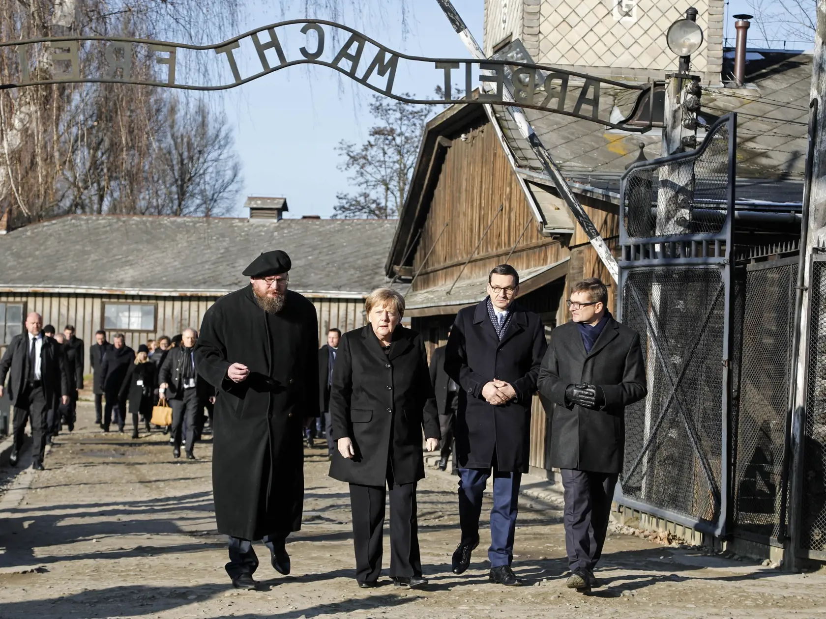 KK21 Osvienčim - Zľava riaditeľ múzea Piotr Cywinski, nemecká kancelárka Angela Merkelová, poľský premiér Mateusz Morawiecki a zástupca riaditeľa múzea Andrzej Kacorzyk  pri vstupe do bývalého nacistického koncentračného tábora Auschwitz-Birkenau v Osvienčime 6. decembra 2019. Nemecká kancelárka Angela Merkelová navštívila v piatok 6. decembra nacistický koncentračný tábor Auschwitz-Birkenau. Je to jej prvá návšteva tohto pamätného miesta, odkedy sa pred 14 rokmi ujala svojho úradu a v poradí tr