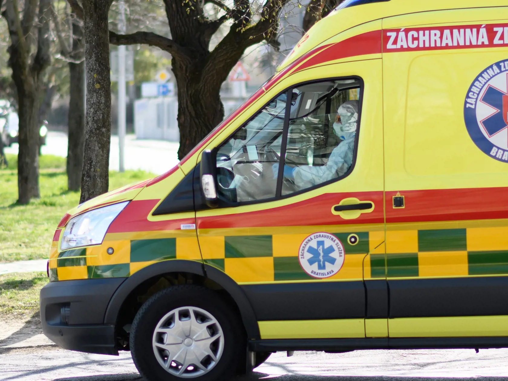 Každý pacient, ktorý chce prísť na vyšetrenie do Fakultnej nemocnice v Nitre, musí prejsť kontrolou. Mieria sa teplota a podpisuje čestné vyhlásenie, že nemáte cestovateľskú anamnézu a neprišli ste do kontaktu s osobou, ktorá bola v zahraničí. Na snímke auto Záchrannej zdravotnej služby vchádza do Fakultnej nemocnice v Nitre 31. marca 2020. FOTO TASR - Henrich Mišovič