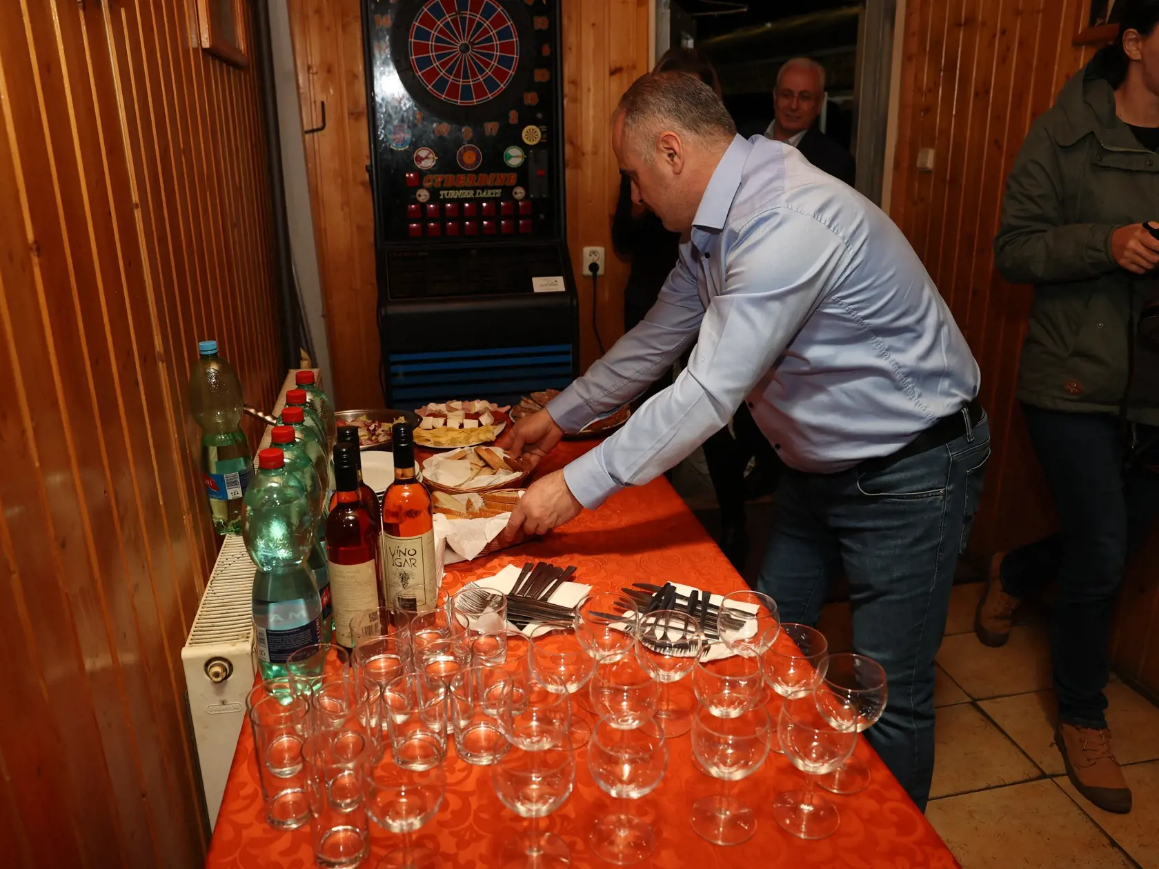 Miestnosť pre médiá v centrále Štefana Harabina. Majiteľ podniku Palmýra club ukladá na stôl s občerstvením určeným pre novinárov ďalšie dobroty.