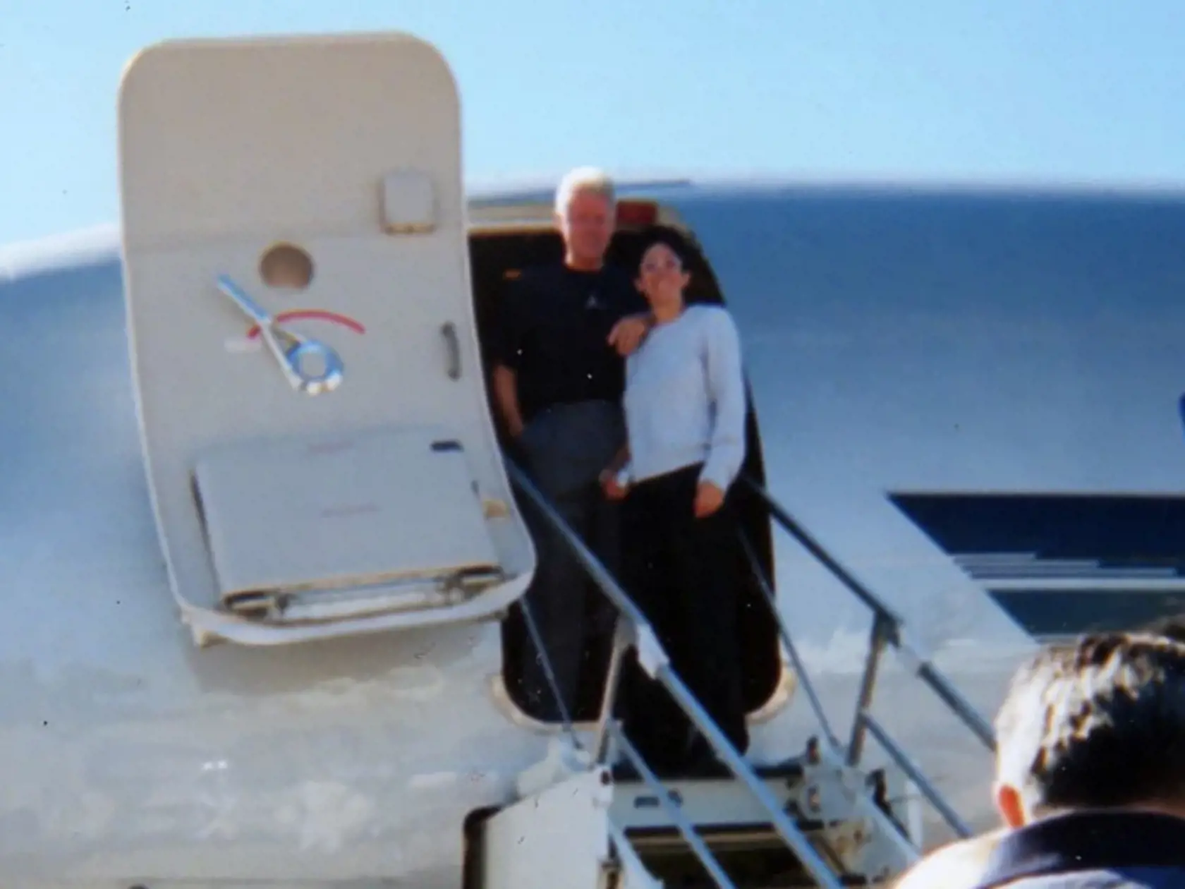 Bill Clinton a Ghislaine Maxwell stoja pred súkromným lietadlom pedofila Epsteina. Fotografia podľa britského denníka The Sun pochádza z čias, kedy sa na palube nachádzala aj Juliette Bryant, ktorá tvrdí, že ju Epstein pravidelne znásilňoval a predával iným vysokopostaveným ľuďom.