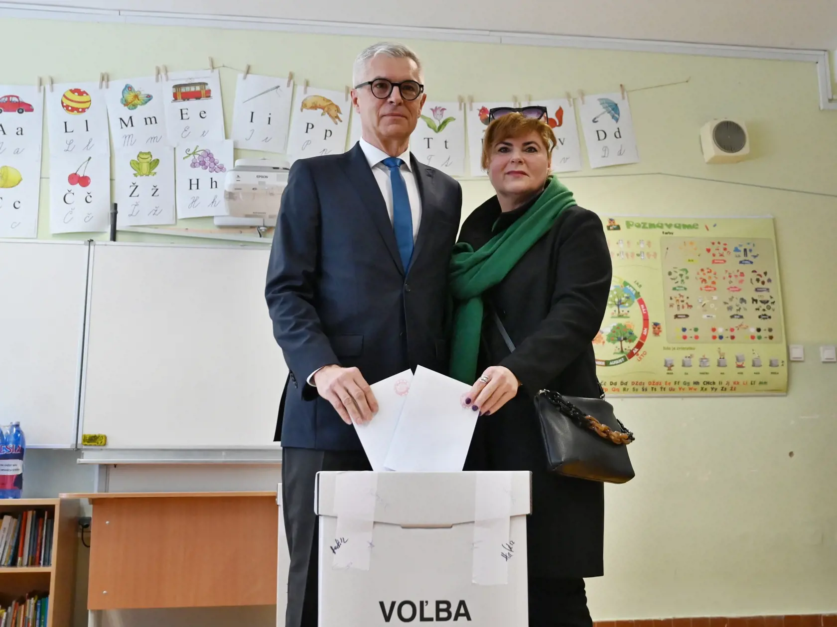 Na snímke vľavo kandidát na prezidenta SR Ivan Korčok s manželkou Soňou vhadzujú obálku s hlasovacím lístkom do volebnej schránky vo volebnej miestnosti v prvom kole prezidentských volieb v Senci v sobotu 23. marca 2024.
