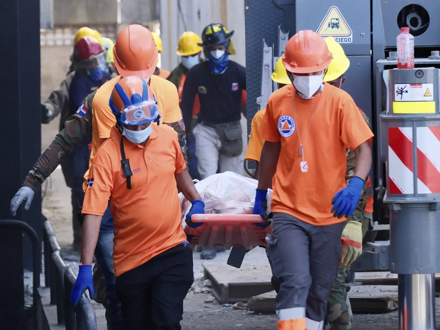 KK6 Santo Domingo - Záchranári nesú telo obete, ktorá zomrela pri zrútení strechy v nočnom klube Jet Set počas koncertu v Santo Domingu, v hlavnom meste Dominikánskej republiky v stredu 9. apríla 2025. Záchranári v Dominikánskej republike v stredu oznámili, že ukončia pátranie po preživších utorňajšieho zrútenia strechy v nočnom klube Jet Set v hlavnom meste Dominikánskej republiky. Počet obetí tejto tragédie už stúpol na viac ako 180 po tom, ako záchranári v stredu našli ďalších 60 tiel. FOTO TASR/AP 
Rescue workers carry the recovered body of a victim who died when the roof collapsed two nights prior at the Jet Set nightclub during a merengue concert, in Santo Domingo, Dominican Republic, Wednesday, April 9, 2025, (AP Photo/Marvin Del Cid)