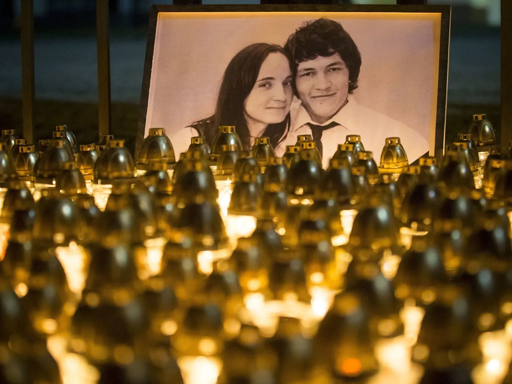 FILE- In this picture taken on Wednesday, Feb. 28, 2018, candles are placed during a silent protest in memory of murdered journalist Jan Kuciak and his girlfriend Martina Kusnirova in Bratislava, Slovakia. On Monday Oct. 1, 2018, Slovakia's prosecutor says a total sum of 70,000 euros ($81,000) was paid for the slayings of an investigative journalist and his fiancee. (AP Photo/Bundas Engler, File)