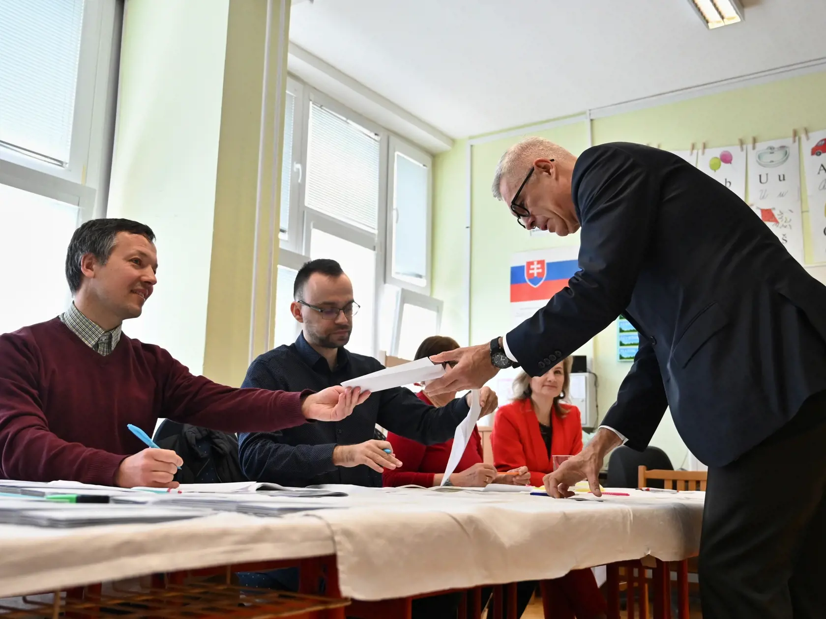 Na snímke kandidát na prezidenta SR Ivan Korčok preberá hlasovacie lístky vo volebnej miestnosti v prvom kole prezidentských volieb v Senci v sobotu 23. marca 2024.