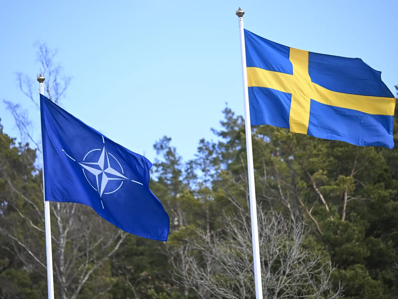 KK70 Štokholm - Na snímke vlajka Severoatlantickej aliancie a švédska vlajka vejú počas ceremoniálu na vojenskej základni v Štokholme 11. marca 2024. Pred budovou sídla Severoatlantickej aliancie v Bruseli v pondelok krátko po poludní slávnostne vztýčili vlajku Švédska, ktoré sa oficiálne stalo 32. členským štátom NATO vo štvrtok 7. marca, informuje TASR. FOTO TASR/AP
The NATO flag, left, is raised next to the Swedish flag during a ceremony at the Musko navy base Stockholm, Monday, March 11, 202