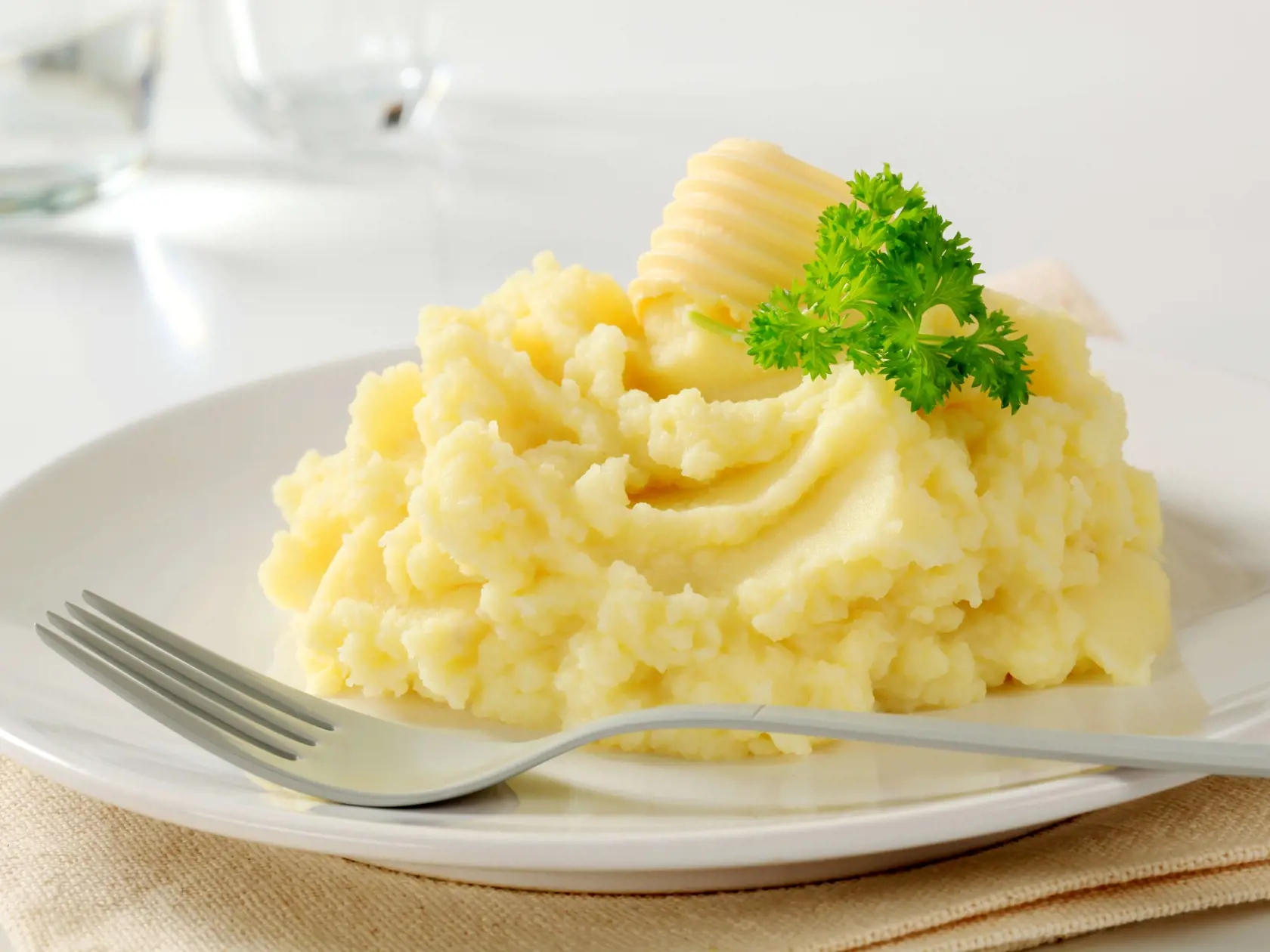 Close-up of mashed potatoes served on white ceramic plate