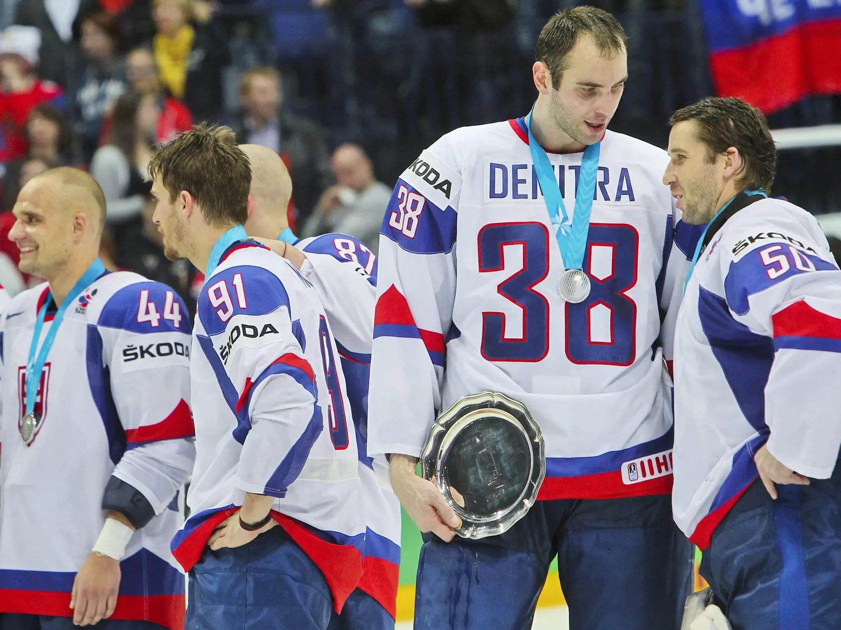 Na snimke uprostred slovensky reprezentant Zdeno Chara, ktory si uctili pamiatku tragicky zosnuleho Pavla Demitru po skonceni finaloveho zapasu hokejovych majstrovstiev sveta 2012 vo finskych Helsinkach medzi reprezentaciami Slovenska a Ruska. Vpravo vedla neho slovensky reprezentant Jan Laco.