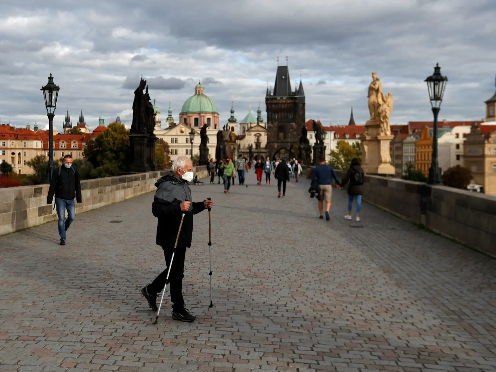 Muž s ochranným rúškom na zabránenie šíreniu nového koronavírusu kráča na stredovekom Karlovom moste v Prahe 8. októbra 2020. V Českej republike pribudlo počas stredy rekordných 5335 nových prípadov nákazy koronavírusom SARS-CoV-2. Je to vôbec najvyšší prírastok od začiatku pandémie.