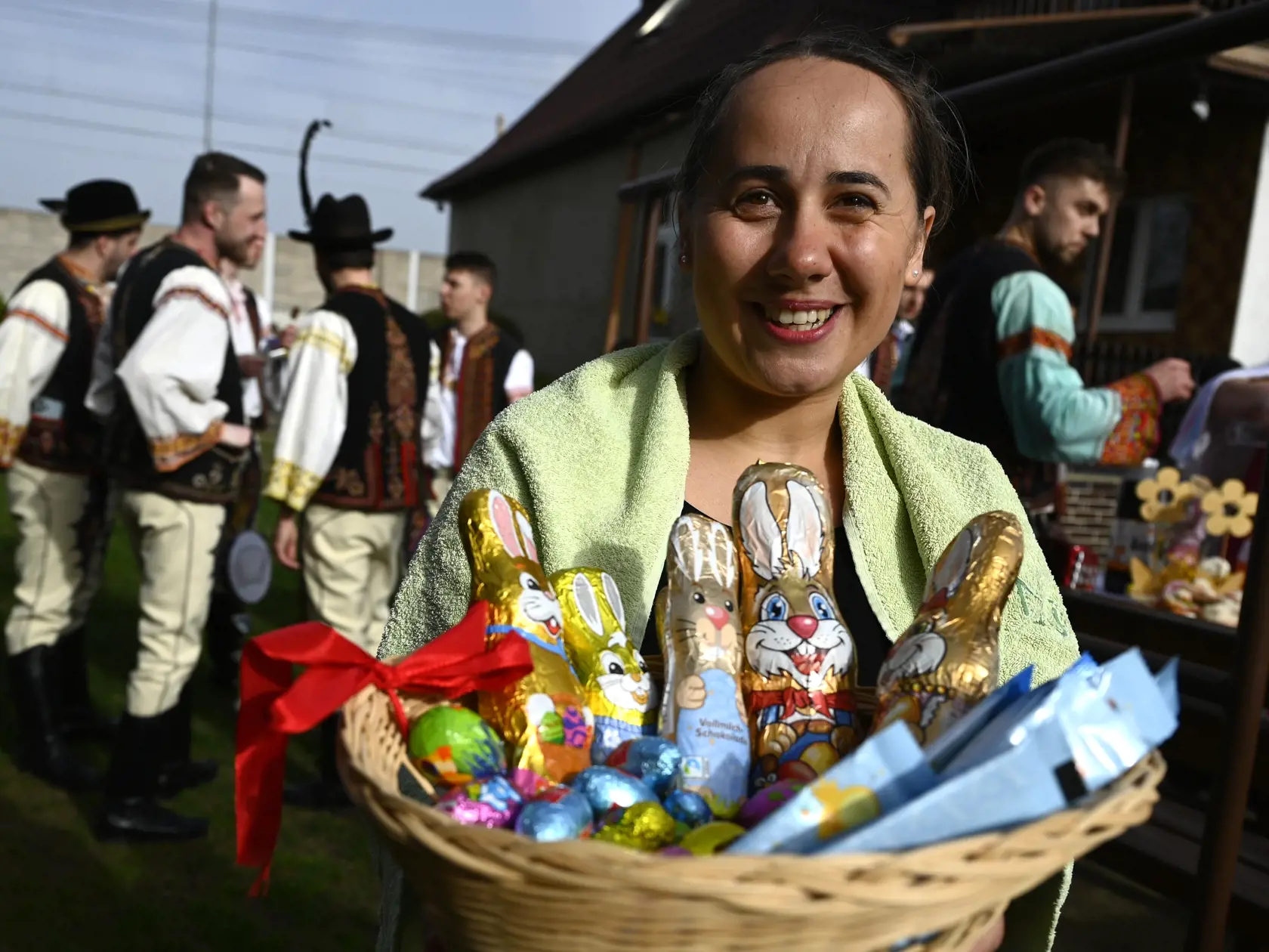 Na snímke žena pózuje s košíkom s čokoládovými  zajacmi a vajíčkami počas veľkonočnej oblievačky a šibačky v obci Trenčianska Teplá v okrese Trenčín v pondelok 1. apríla 2024.