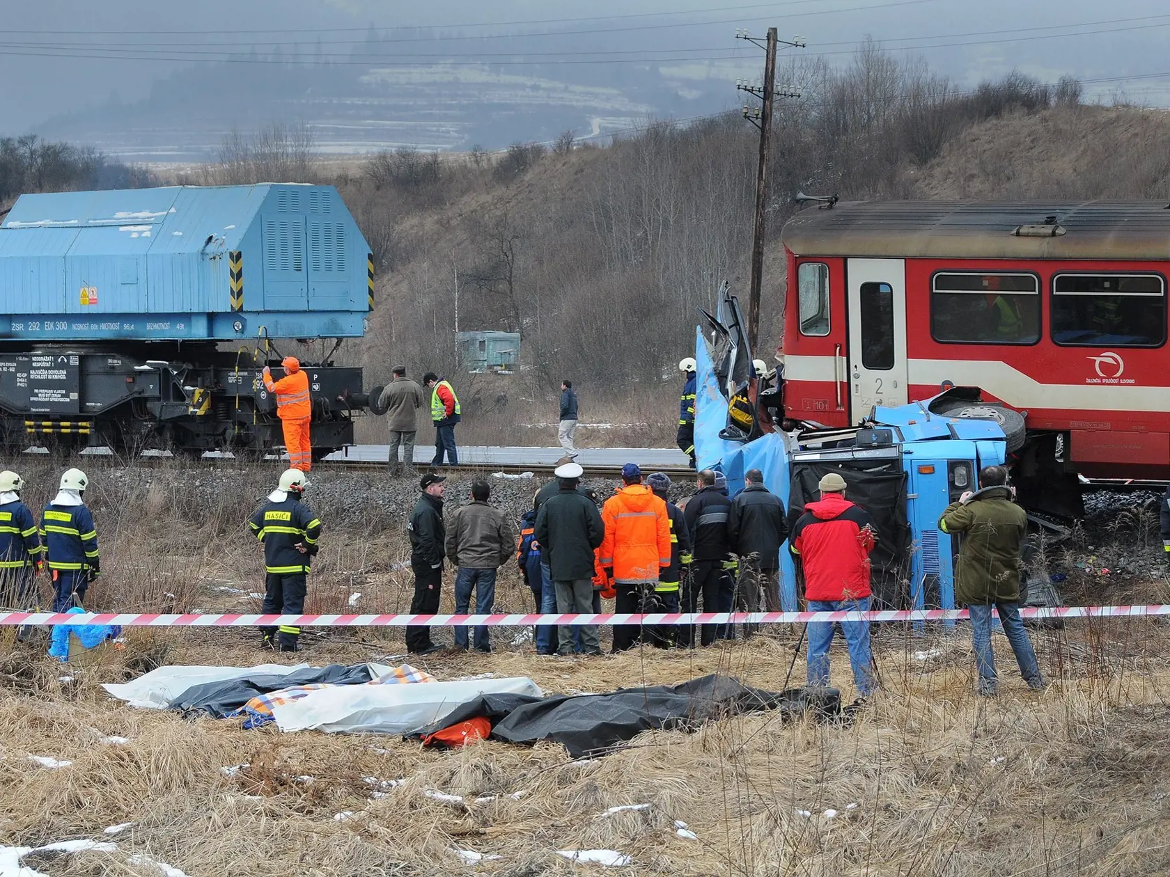 Vána dopravná nehoda autobusu a vlaku sa stala 21. februára 2009 v obci Polomka na Horehroní. Autobus sa pri prechádzaní eleznièným priecestím zrazil s vlakom. Na snímke miesto nehody, v popredí zakryté telá obetí. FOTO TASR - Michal Svítok *** Local Caption *** bánovskí bebravskobánovskí cestujúci ¾udské ivoty lyiarsky zájazd màtvi zranení