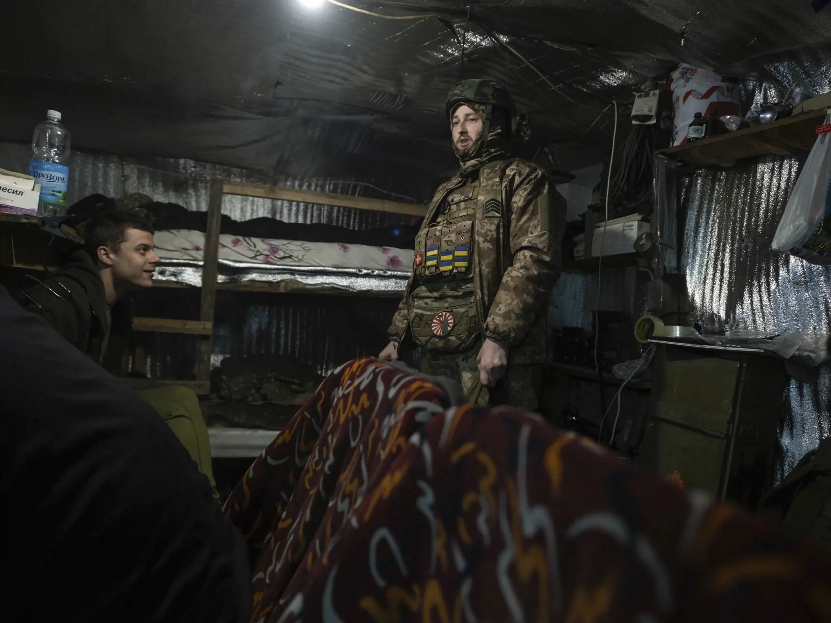 Ukrajinskí vojaci sa rozprávajú v bunkri na frontovej línii pri dedine Kliščiivka južne od mesta Bachmut v Doneckej oblasti na východe Ukrajiny v pondelok 18. marca 2024.