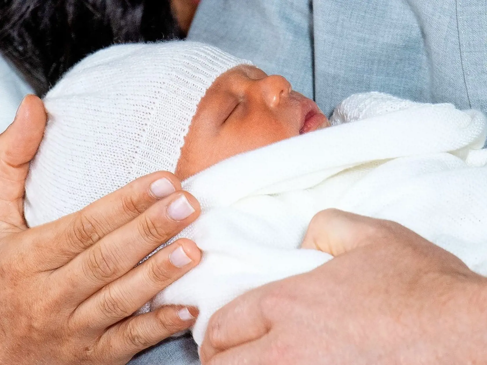 Malý Archie má pod čiapkou vlasy, šťastní rodičia Meghan a Harry neukázali, akej farby.