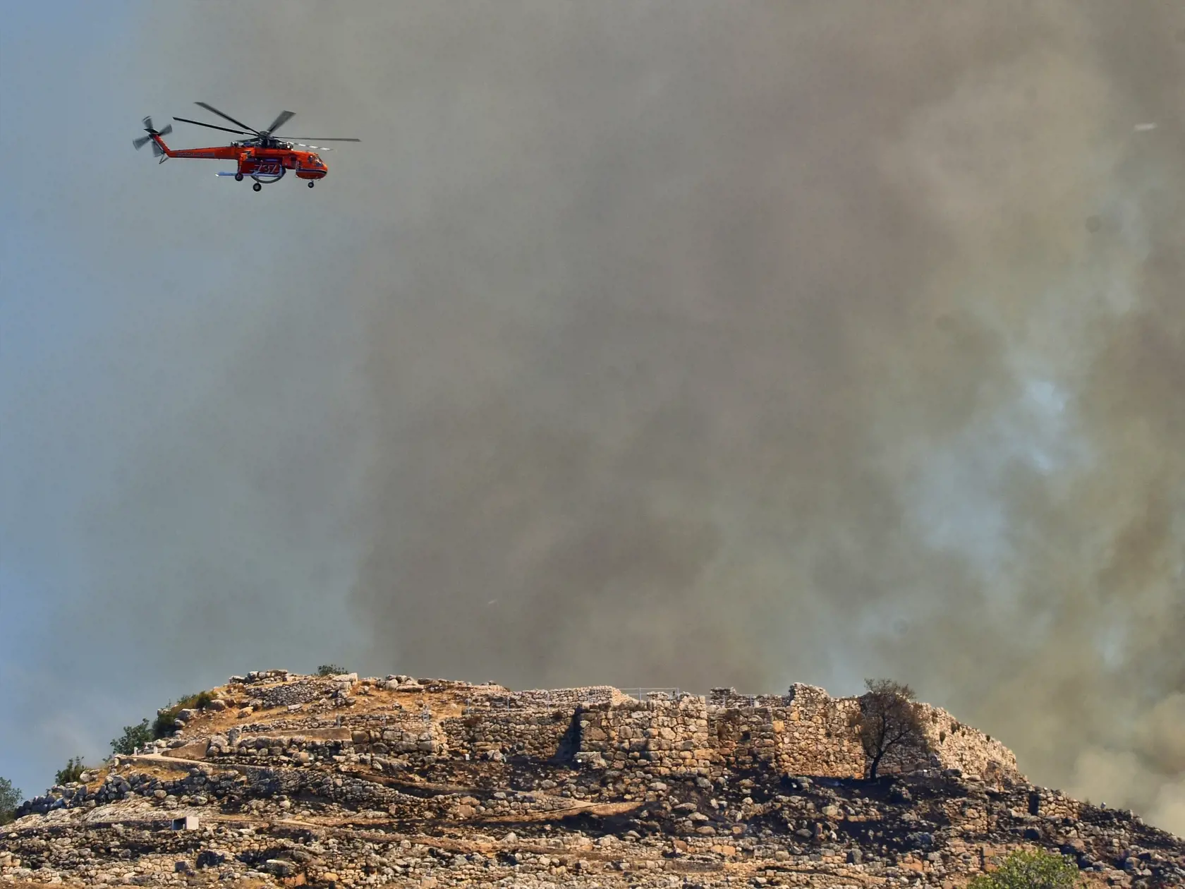 Helikoptéra zasahuje počas lesného požiaru nad starogréckym mestom Mykény.