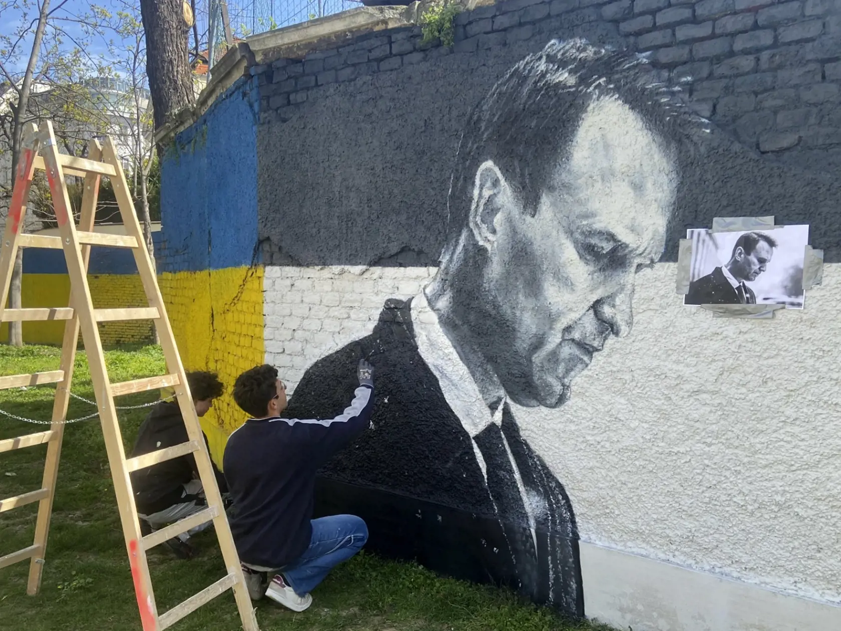 Rakúske graffiti duo Joel Gamnou maľuje maľbu s portrétom zosnulého ruského opozičného lídra Alexeja Navaľného na múre vo Viedni 27. marca 2024.