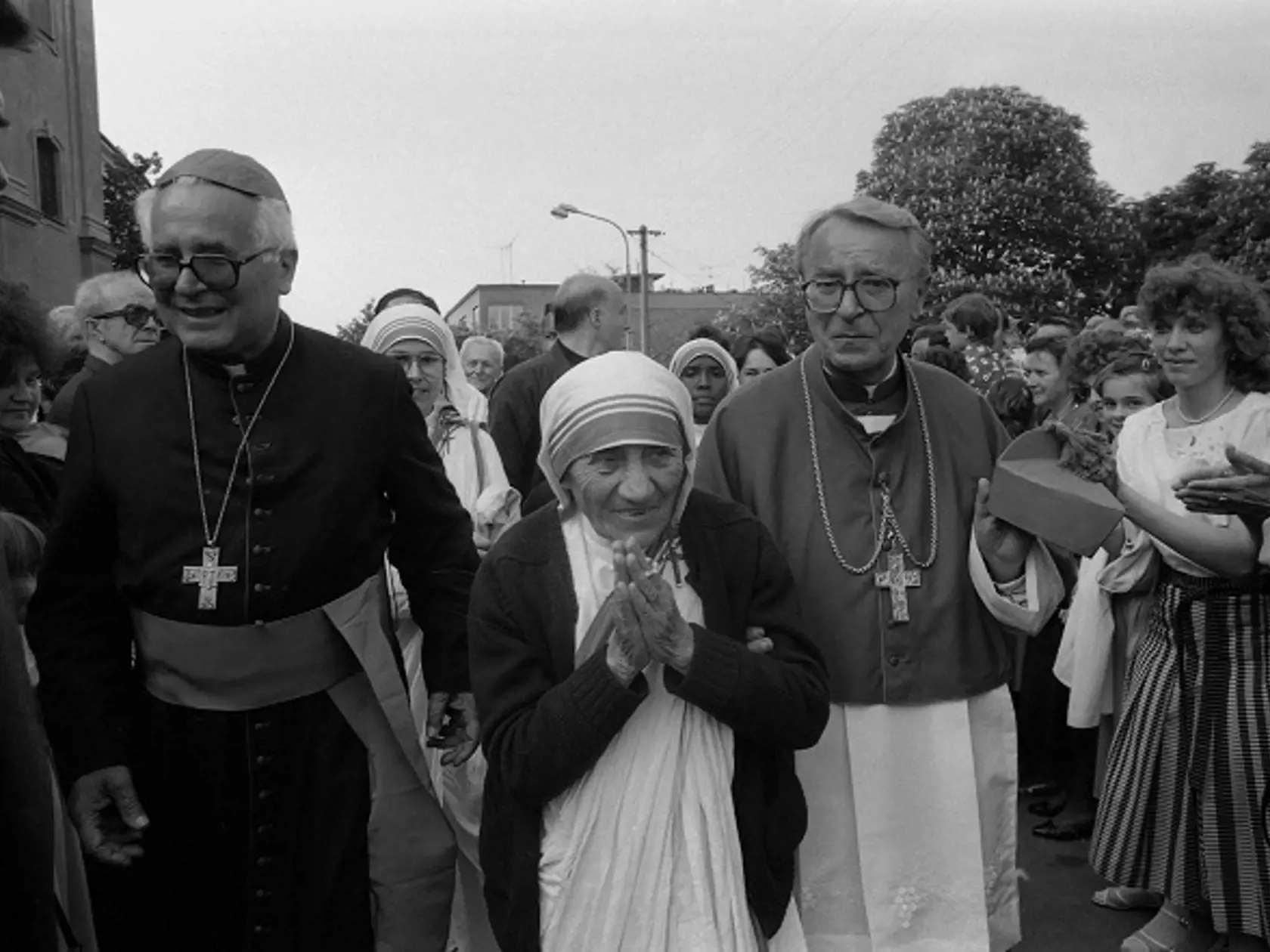 Na archívnej snímke z 13. mája 1990 Matka Tereza v Nitre. Významná prestaviteľka kresťanského sveta Matka Tereza z Kalkaty, nositeľka Nobelovej ceny za mier, prišla 13. mája na 3-dňovú návštevu Slovenska. Zavítala do starobylej Nitry, kde sa k jej slávnostnému uvedeniu konala v kostole Piaristov svätá omša. Kocelebrovali ju nitriansky biskup mons. Ján Chryzostom Korec a biskup mons. Pavol Hnilica. Na snímke zľava biskup Pavol Hnilica, Matka Tereza a biskup Ján Chryzostom Korec medzi nitrianskymi