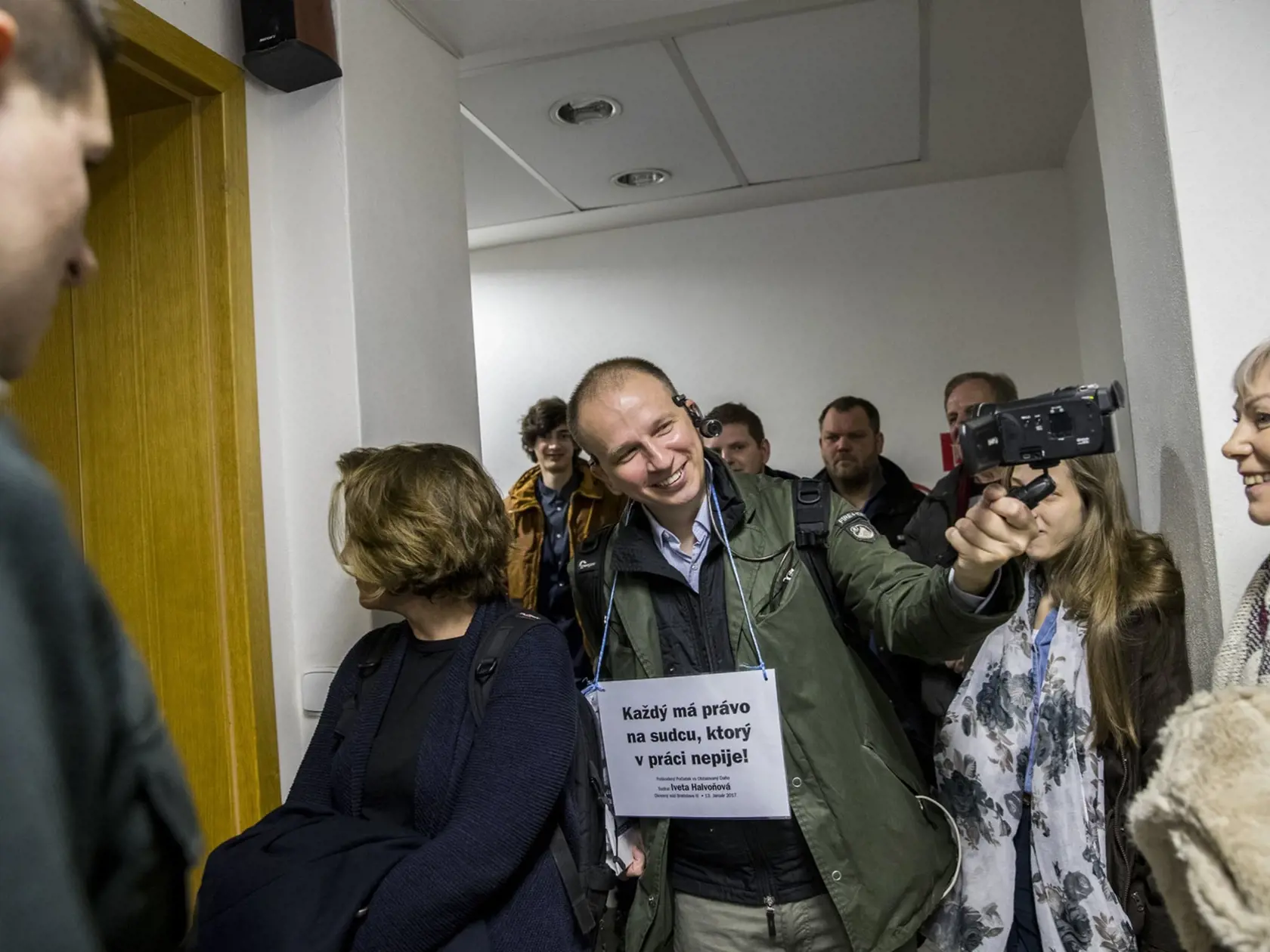 Kontroverzný aktivista Martin Daňo pobehoval po chodbách súdu so zaujímavo znejúcim transparentom na krku.