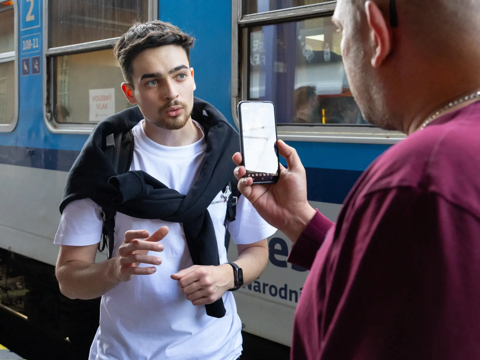 Predseda občianskeho združenia Mladí Marek Mach vysvetľuje aktivistovi priamo na Hlavnej stanici v Bratislave, ako to vlastne bolo s volebným vlakom.