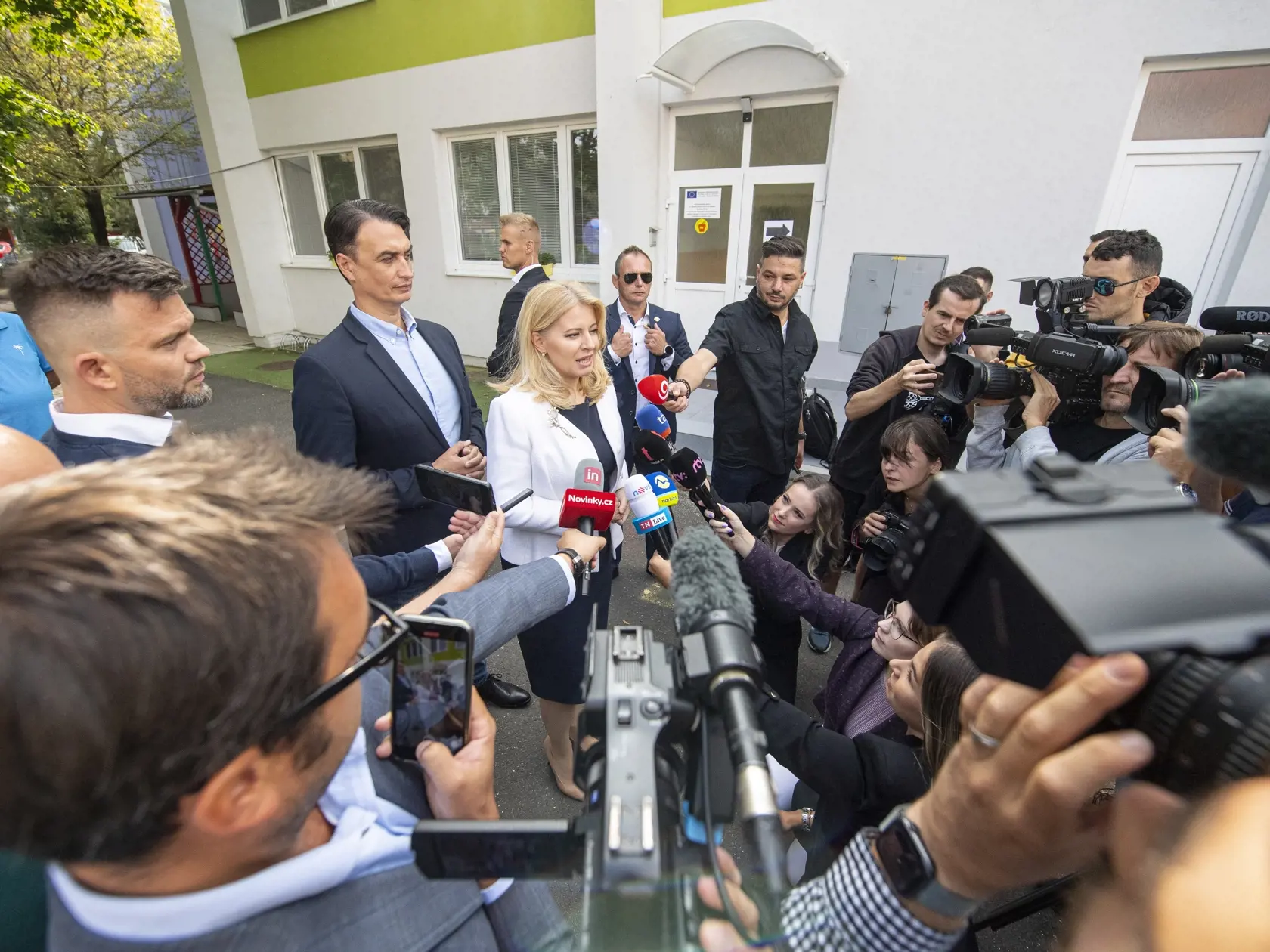Prezidentka SR Zuzana Čaputová hovorí s novinármi po hlasovaní v Pezinku počas predčasných parlamentných volieb na Slovensku v sobotu 30. septembra 2023. Za ňou stojí Juraj Rizman.