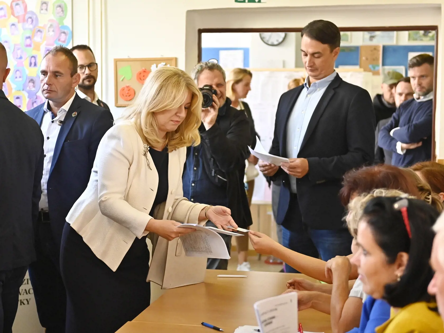 Prezidentka SR Zuzana Čaputová si preberá s partnerom Jurajom Rizmanom hlasovacie lístky vo volebnej miestnosti v Pezinku počas predčasných parlamentných volieb na Slovensku v sobotu 30. septembra 2023.