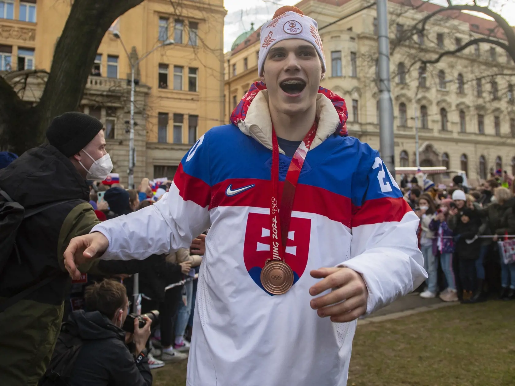 Bronzoví medailisti z olympijského hokejového turnaja v Pekingu sa v utorok vrátili domov na Slovensko, kde ich čakalo veľkolepé privítanie. Následne autobus s hráčmi zamieril do Bratislavy, kde ich najprv čakali mediálne povinnosti a následne sa vydali na okružnú jazdu kabrioautobusom po meste. Na snímke slovenský hokejista Juraj Slafkovský počas osláv na Námestí SNP v Bratislave 22. februára 2022. FOTO TASR - FOTO TASR - Jakub Kotian