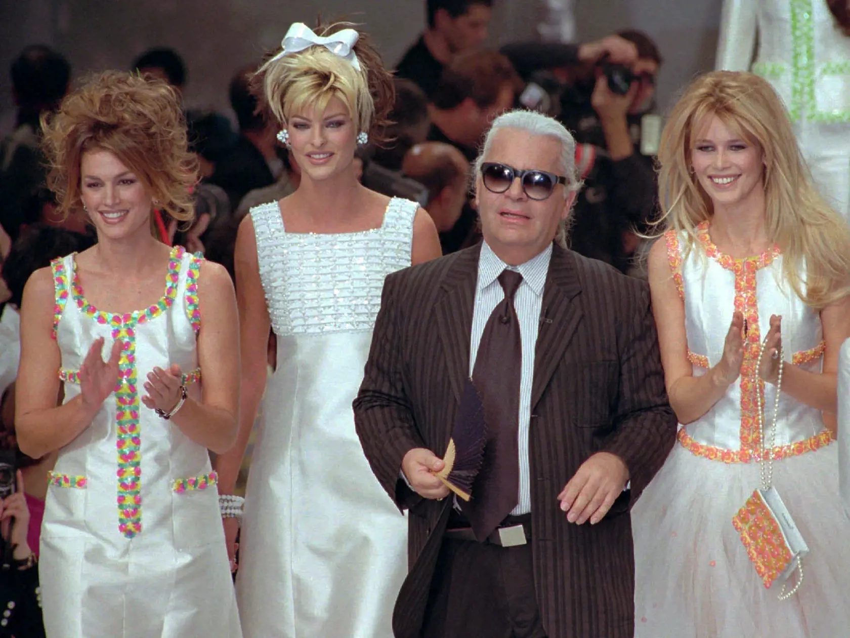Na archívnej snímke z 19. októbra 1995 nemecký módny návrhár Karl Lagerfeld a modelky zľava Cindy Crawford, Linda Evagelista a Claudia Schiffer pózujú na konci módnej prehliadky značky Chanel v Paríži.