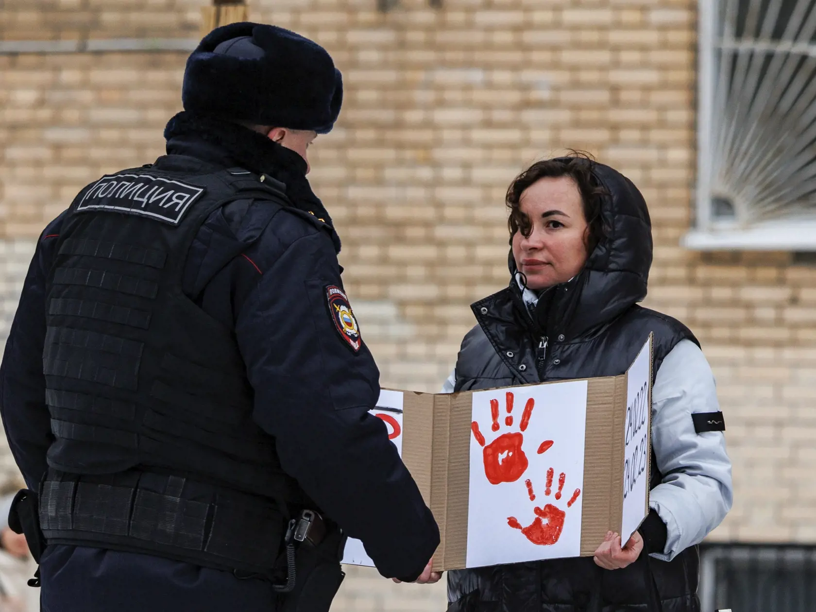 Policajt zadržiava ženu s plagátom pri soche ukrajinskej spisovateľky Lesii Ukrajinky počas prvého výročia ruskej agresie na Ukrajinu 24. februára 2023 v Moskve.