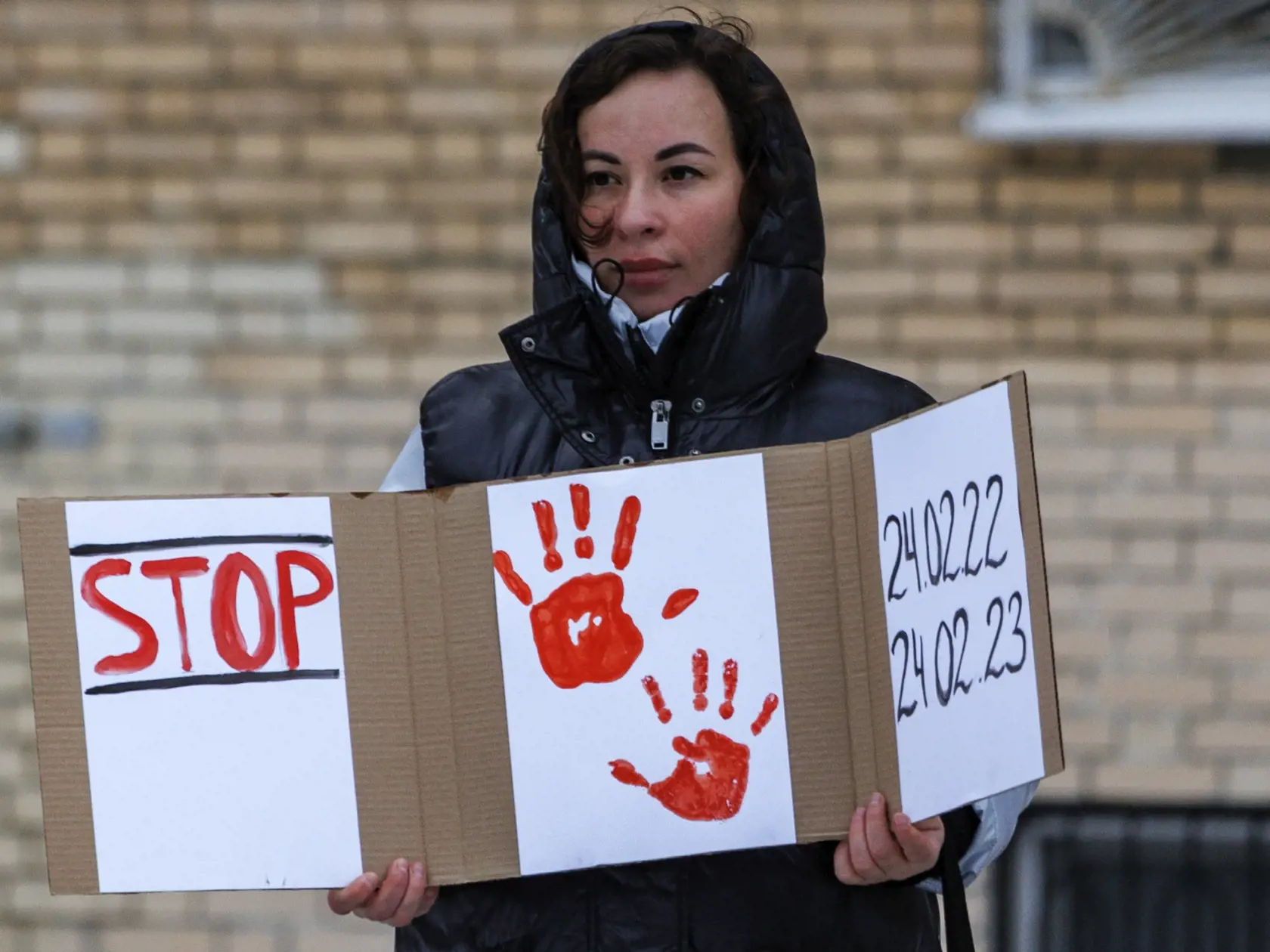 Žena drží plagát pri soche ukrajinskej spisovateľky Lesii Ukrajinky počas prvého výročia ruskej agresie na Ukrajinu 24. februára 2023 v Moskve.