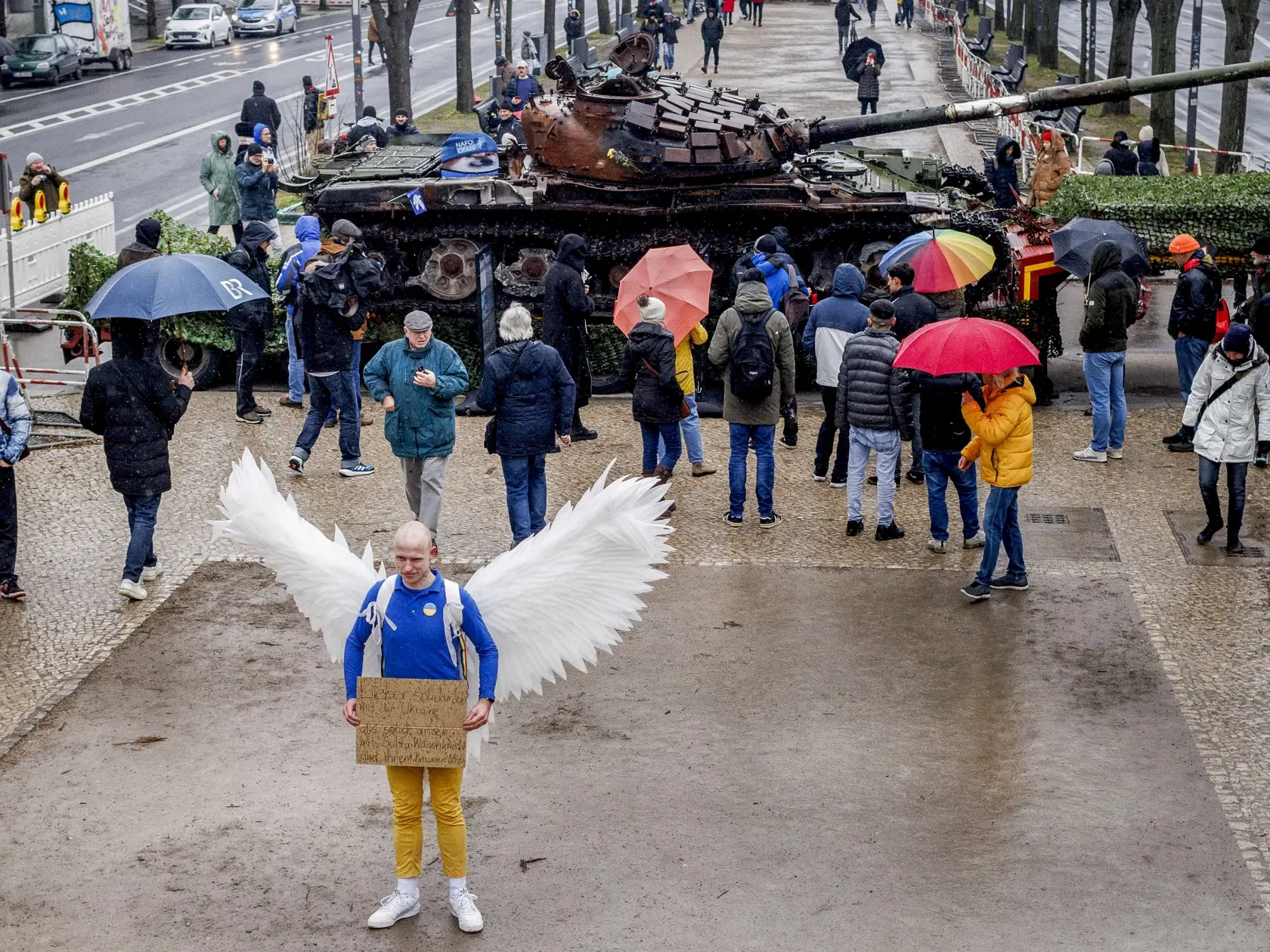 Na snímke muž oblečený za holubicu stojí pred hrdzavejúcim ruským tankom T-62, ktorý je vystavený pred ruským veľvyslanectvom v deň prvého výročia ruskej invázie na Ukrajinu 24. februára 2023 v Berlíne.